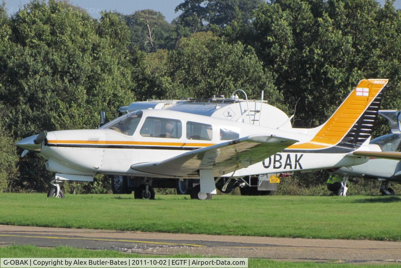G-OBAK, 1977 Piper PA-28R-201T Cherokee Arrow III C/N 28R-7703054, Parked on the grass, in its now old colours.
