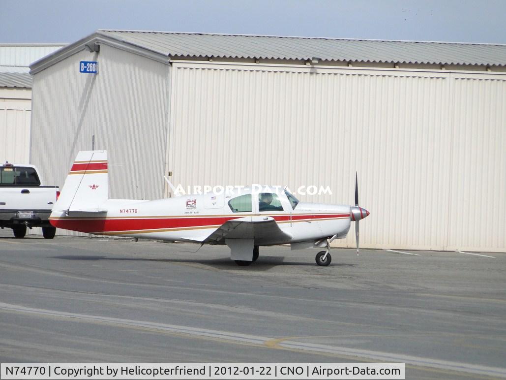 N74770, 1961 Mooney M20B Mark 21 C/N 1770, Taxiing between the hangers, with 2 other ships heading towards runway 26