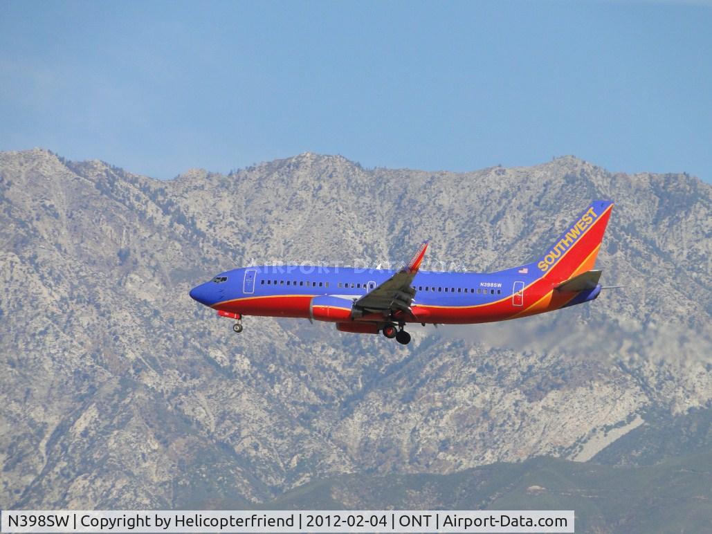 N398SW, 1995 Boeing 737-3H4 C/N 27692, Approaching the outer fence of runway 26R, below the mountains north of the airport