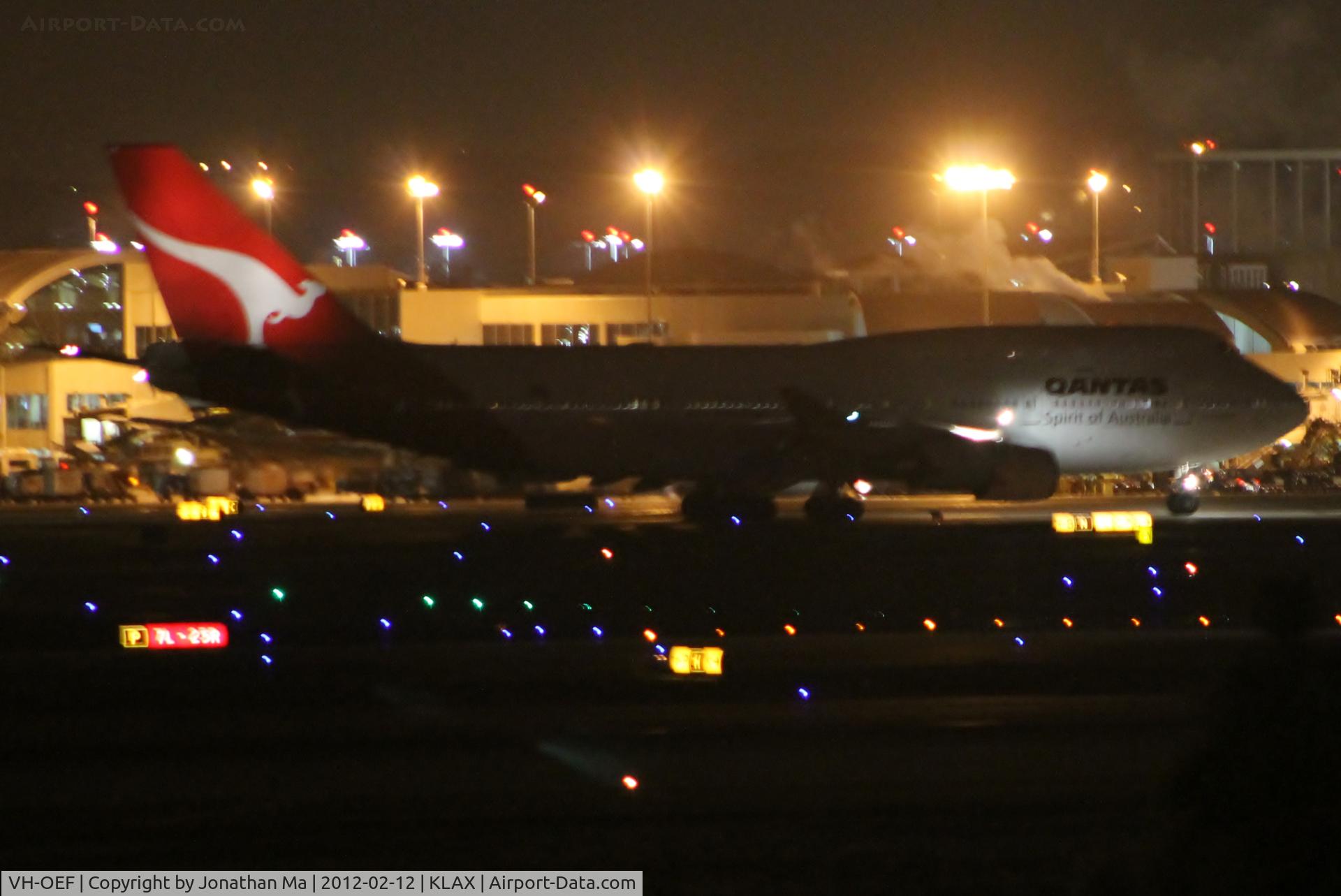 VH-OEF, 2002 Boeing 747-438/ER C/N 32910, Qantas 747 in old colors taxies past VH-OEG at 1206AM
