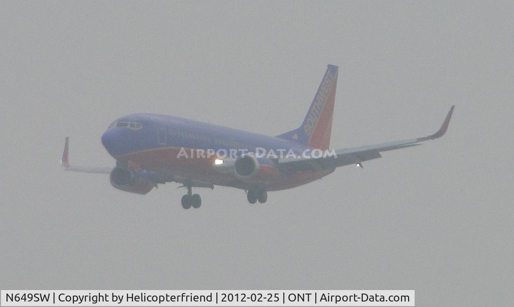N649SW, 1997 Boeing 737-3H4 C/N 27719, On final for 26R half mile out and coming out of the low clouds