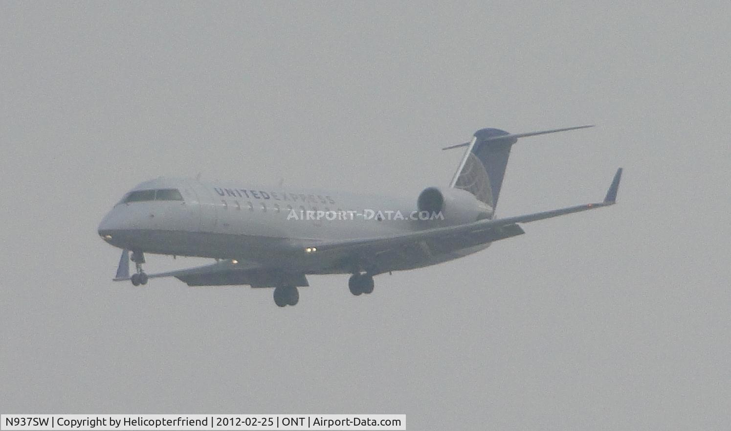 N937SW, 2003 Bombardier CRJ-200LR (CL-600-2B19) C/N 7735, On final for 26R half mile out and coming out of the low clouds