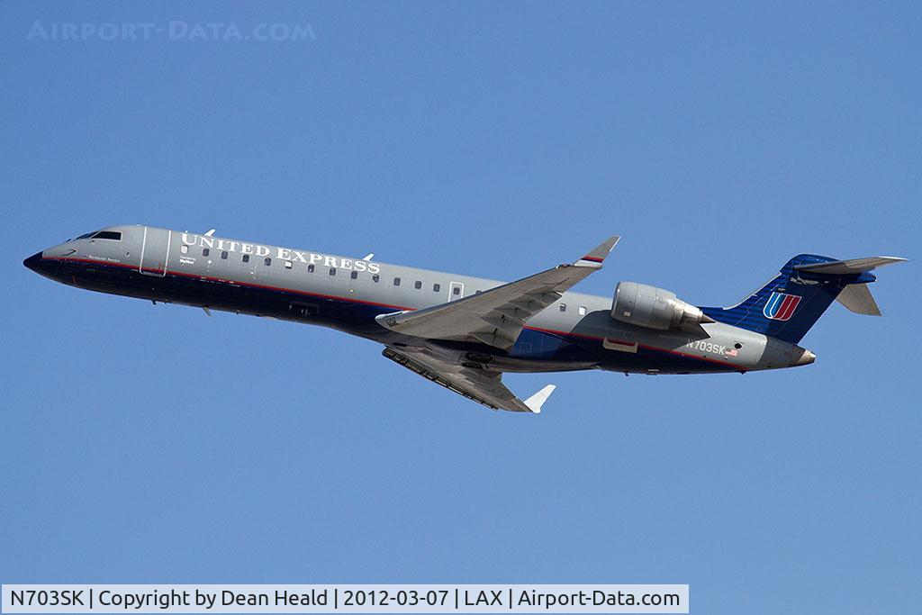 N703SK, 2004 Bombardier CRJ-701ER (CL-600-2C10) Regional Jet C/N 10139, United Express (SkyWest Airlines) N703SK (FLT SKW6230) climbing out from RWY 25R en route to Austin-Bergstrom Int'l (KAUS).