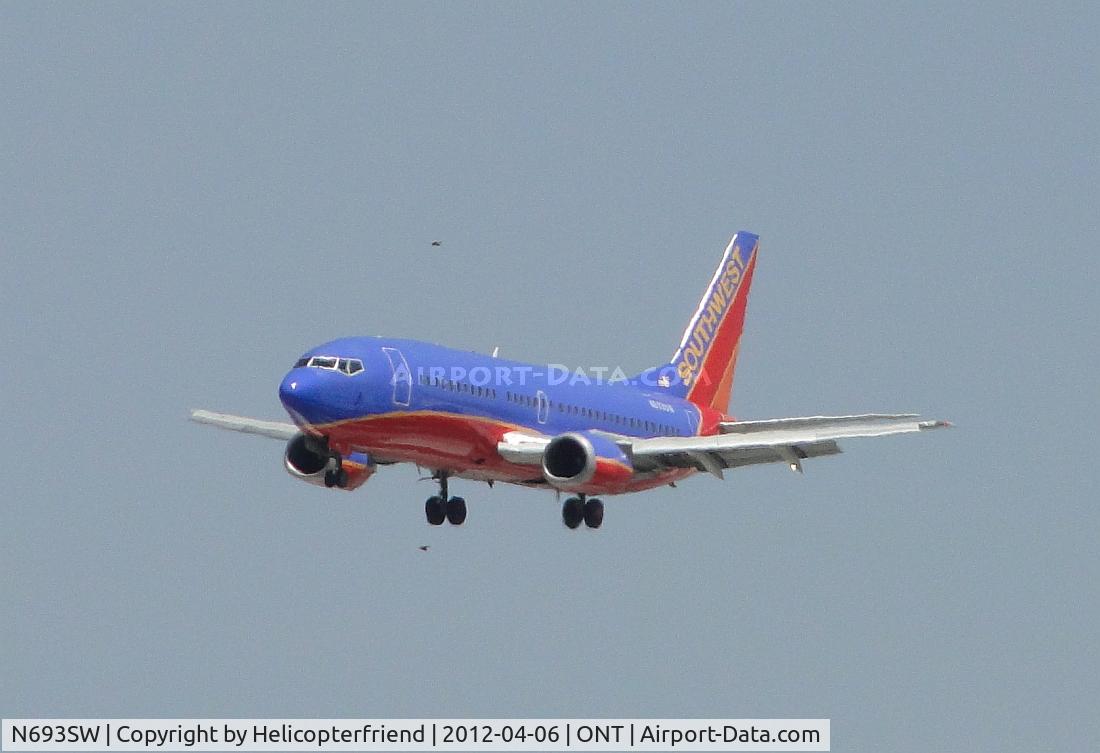 N693SW, 1985 Boeing 737-317 C/N 23174, On final for 26R and looks like she is being escorted above and below by the hawks from the approach area
