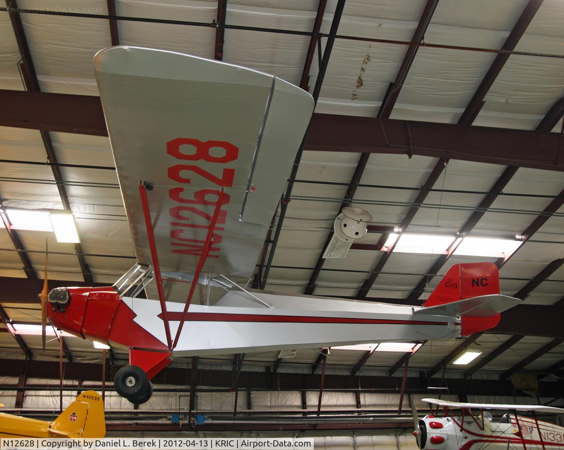 N12628, 1932 Taylor E-2 C/N 33, A genuine Taylor E-2 Cub hangs, in contrast to the more famous Piper 3C in the background.