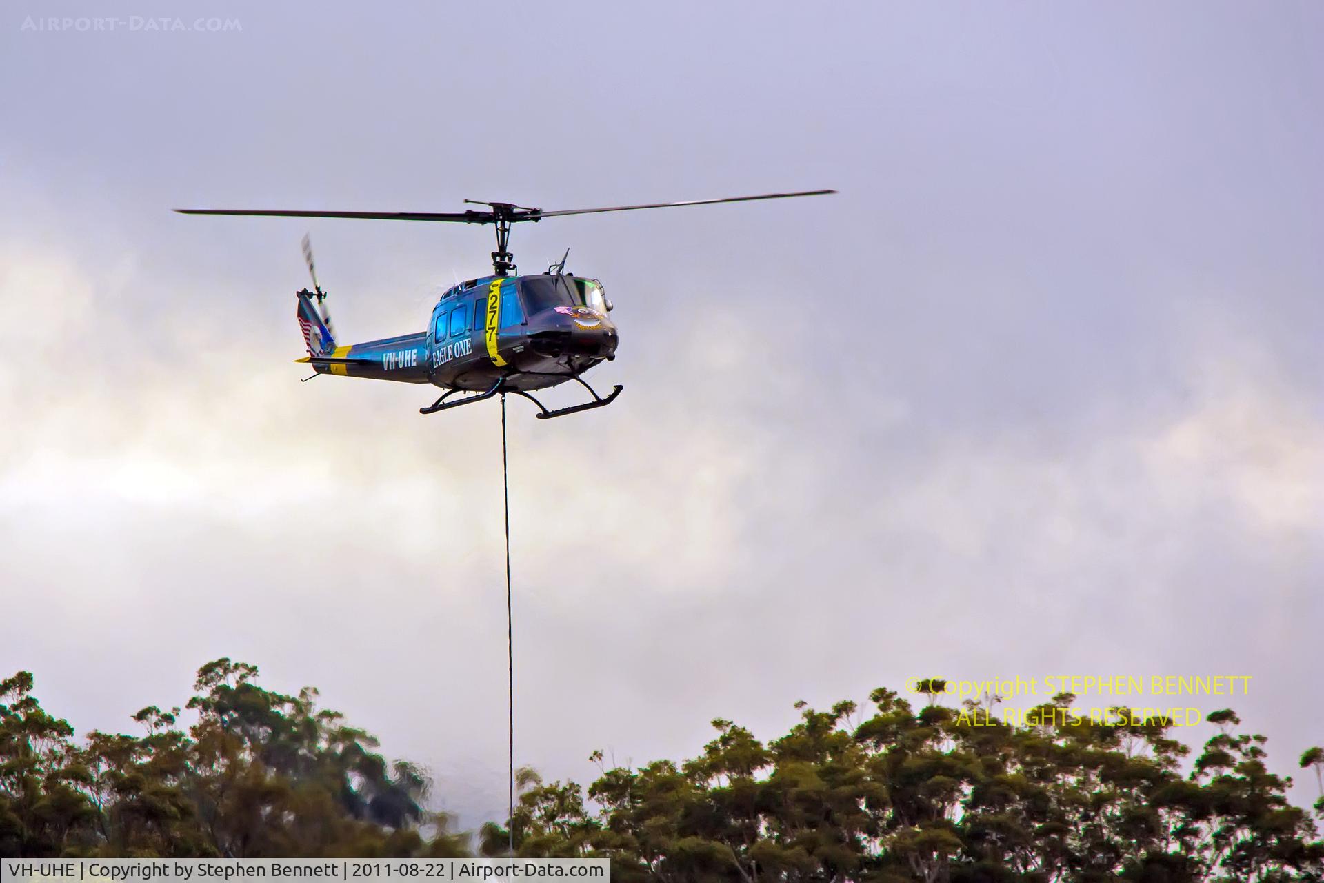 VH-UHE, 1966 Bell UH-1H Iroquois C/N 5995, Hovering, delivering landscaping supplies