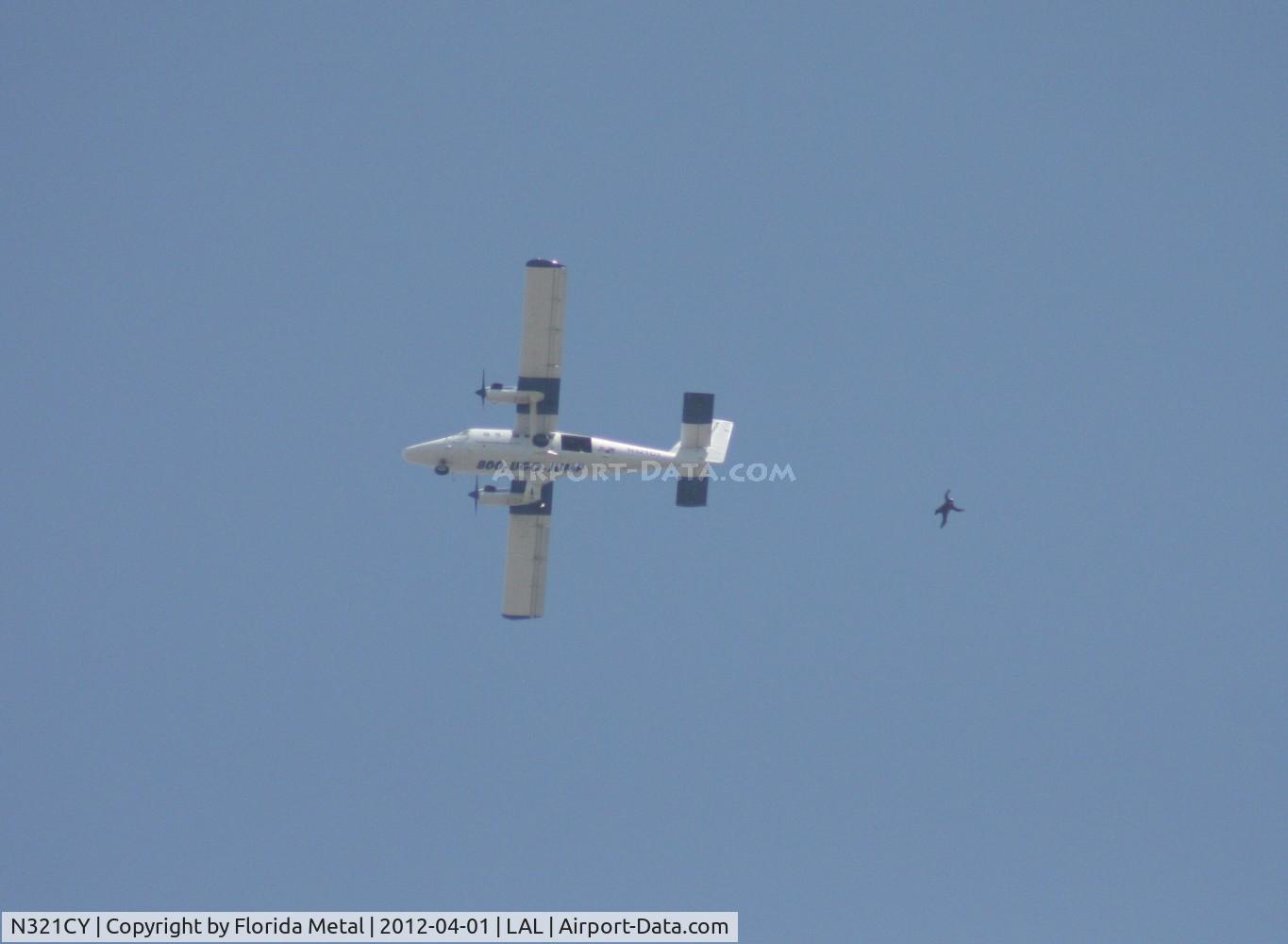 N321CY, 1968 De Havilland Canada DHC-6-200 Twin Otter C/N 211, SOCOM jumper seen flying through the air below the jump plane