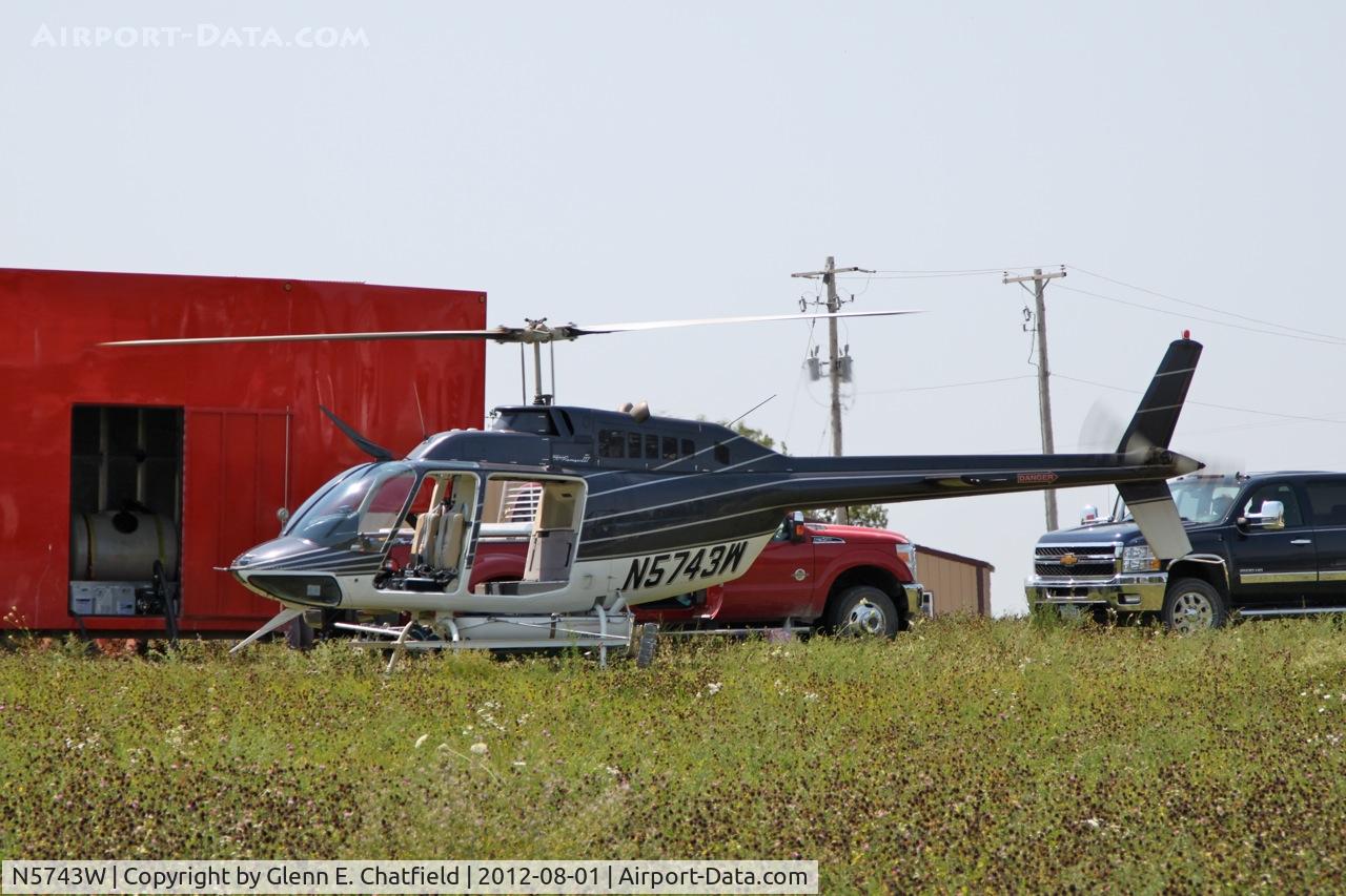 N5743W, 1980 Bell 206B C/N 3050, Taking on another load for crop dusting.  At the SE corner of county routes W38 and A38, about six miles NE of Decorah, IA