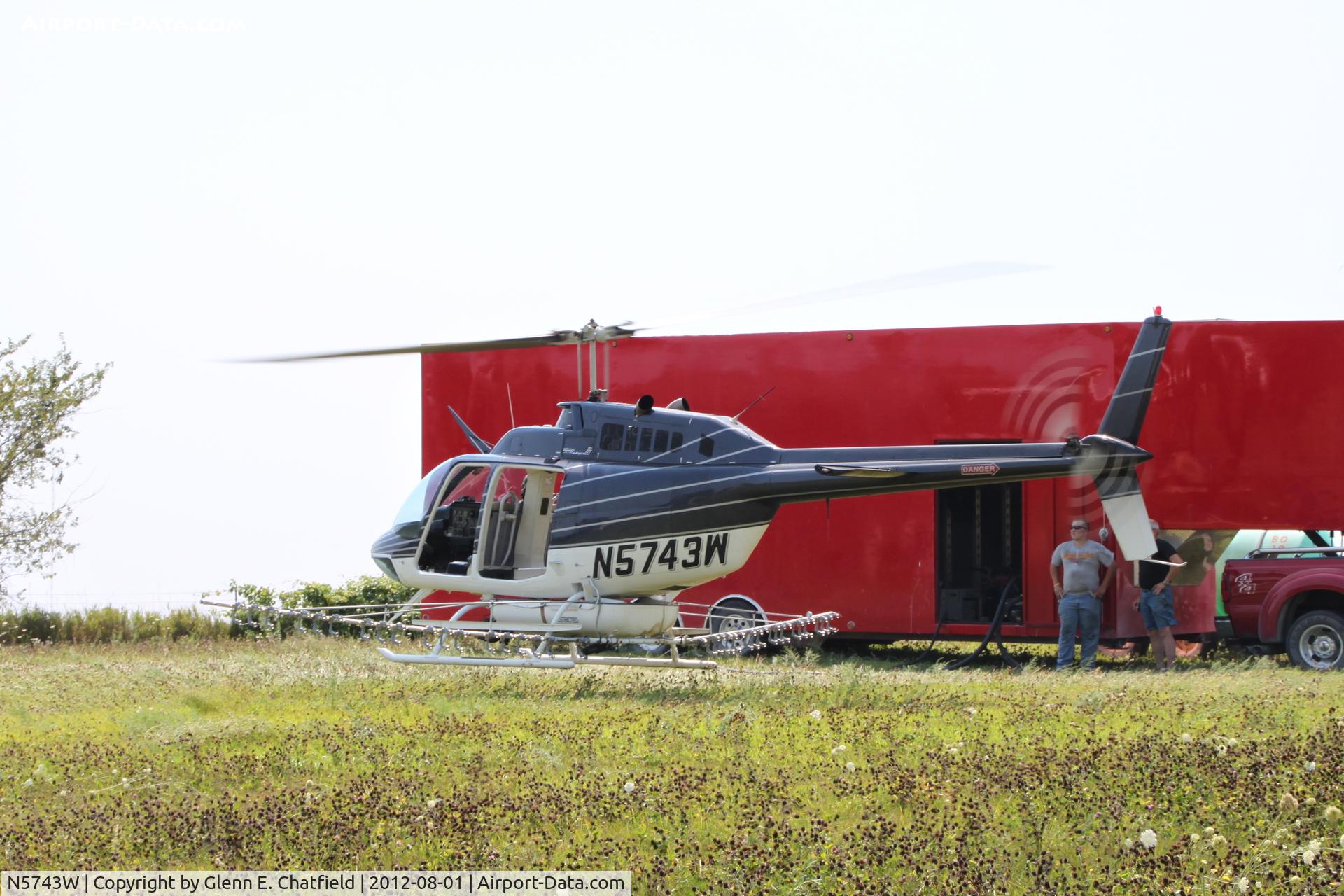 N5743W, 1980 Bell 206B C/N 3050, Taking off with another load for crop dusting. At the SE corner of county routes W38 and A38, about six miles NE of Decorah, IA
