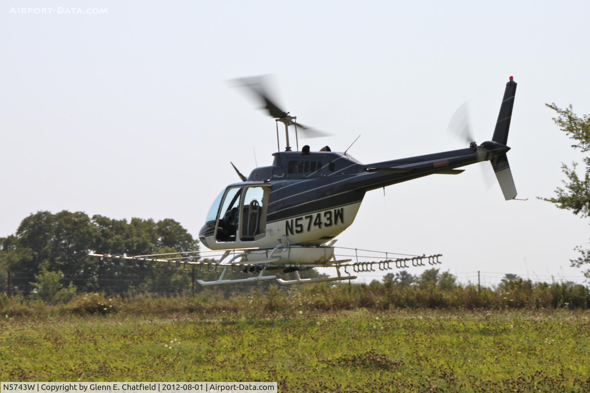 N5743W, 1980 Bell 206B C/N 3050, Taking off with another load for crop dusting. At the SE corner of county routes W38 and A38, about six miles NE of Decorah, IA
