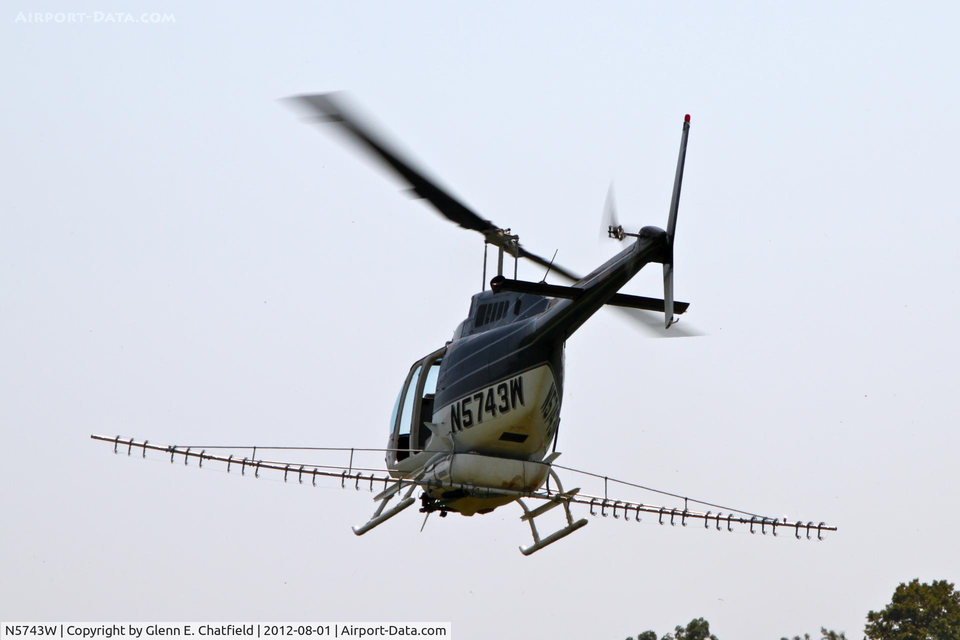 N5743W, 1980 Bell 206B C/N 3050, Taking off with another load for crop dusting. At the SE corner of county routes W38 and A38, about six miles NE of Decorah, IA