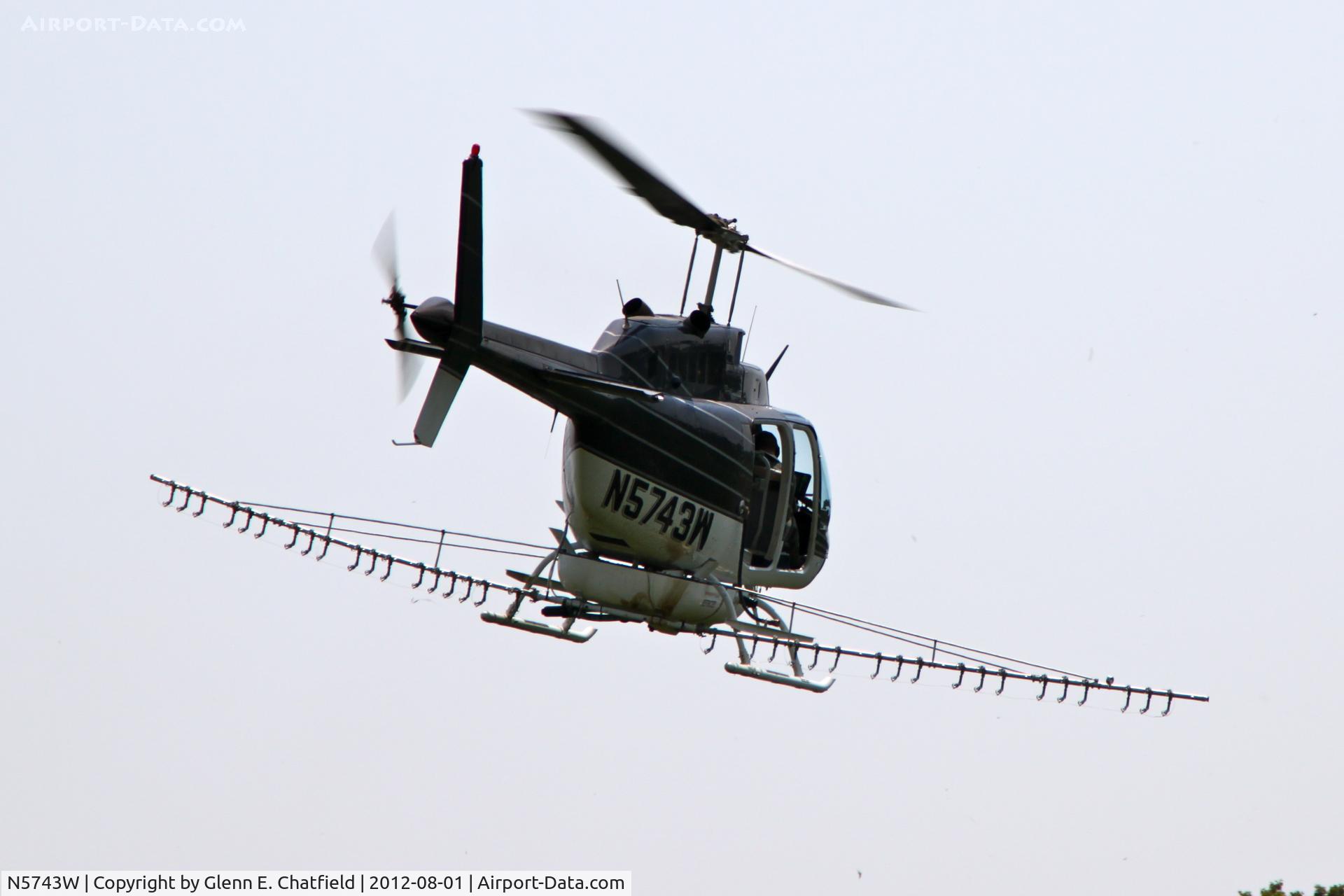 N5743W, 1980 Bell 206B C/N 3050, Taking off with another load for crop dusting. At the SE corner of county routes W38 and A38, about six miles NE of Decorah, IA