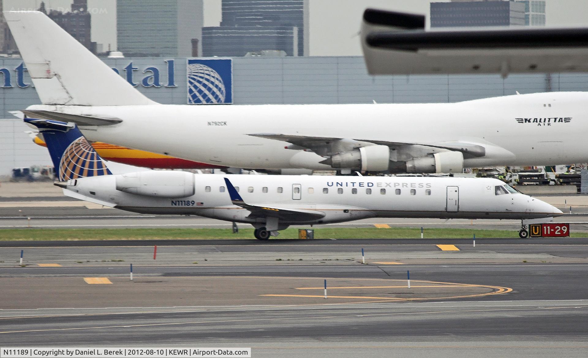N11189, 2005 Embraer ERJ-145XR (EMB-145XR) C/N 14500931, A United Express regional jet appears to be overshadowed by the jumbo freighters in the background.