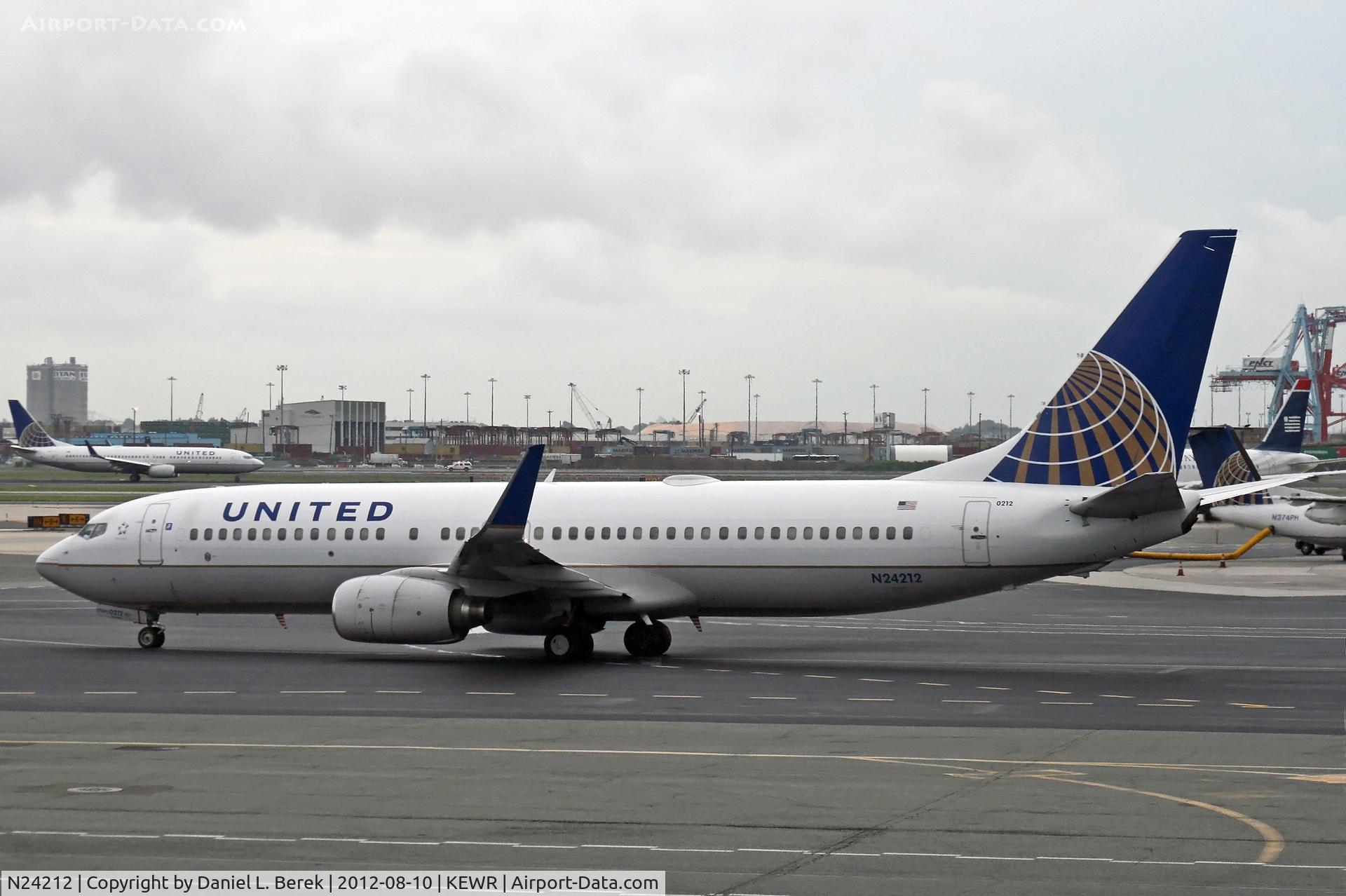 N24212, 1998 Boeing 737-824 C/N 28772, A United Boeing 737-800 taxies out at a very soggy Newark Airport.