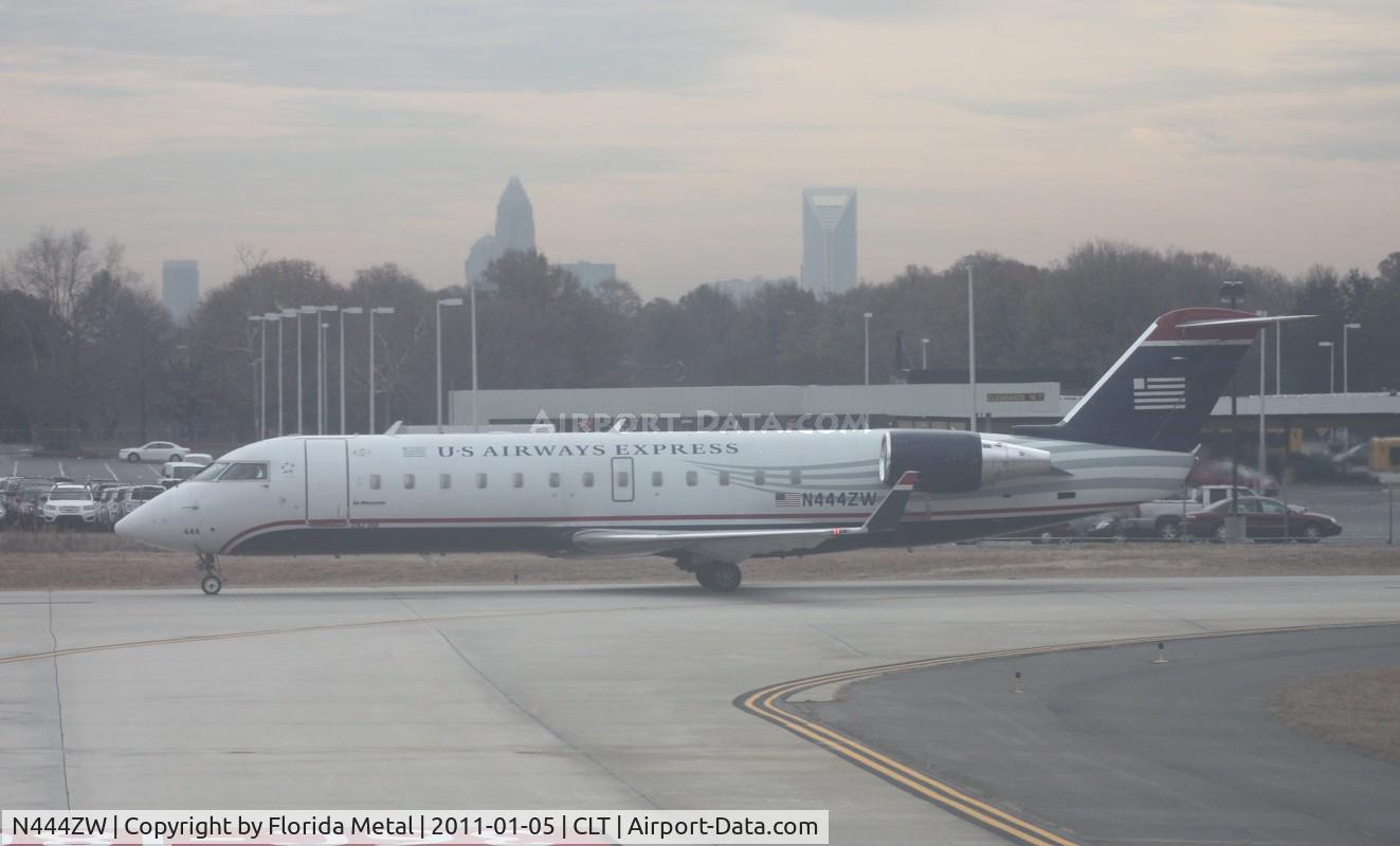 N444ZW, 2003 Canadair CRJ-200LR (CL-600-2B19) C/N 7788, US Airways Express CRJ - taken out of the window of the US Airways A319 (N744P - Piedmont retro) I was on.  The windows were hazed, not making for the best pictures - Downtown Charlotte in the background