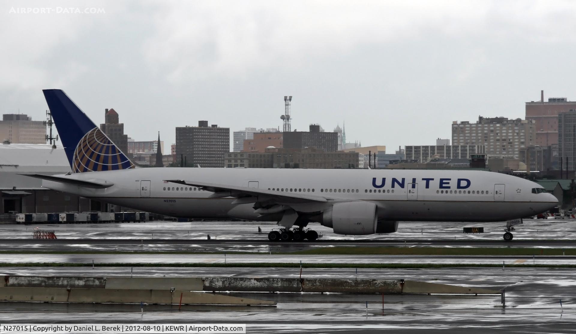 N27015, 2000 Boeing 777-224/ER C/N 28678, An ex-Continental Triple-7 taxies by on a very wet Newark ramp just after a downpour.