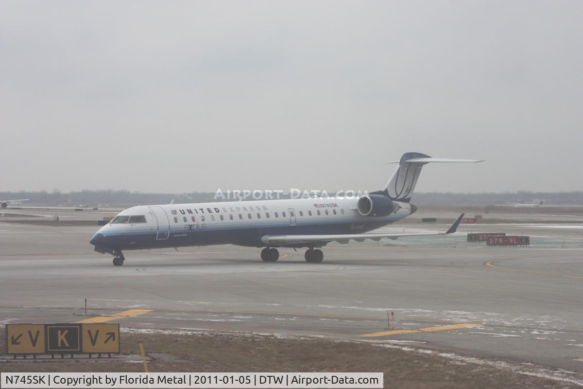 N745SK, 2005 Bombardier CRJ-701ER (CL-600-2C10) Regional Jet C/N 10201, United Express CRJ-700 taken out of the dirty window of N744P