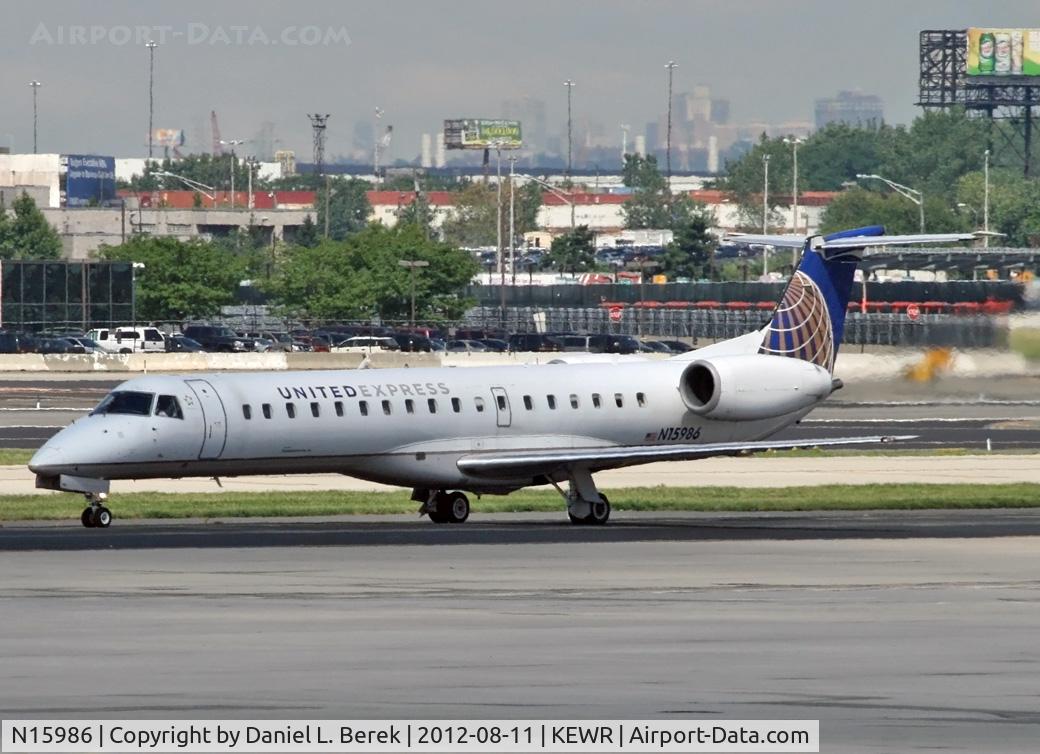 N15986, 2000 Embraer ERJ-145LR (EMB-145LR) C/N 145254, The sun shines on a United Express ERJ after a rainstorm at Newark International.