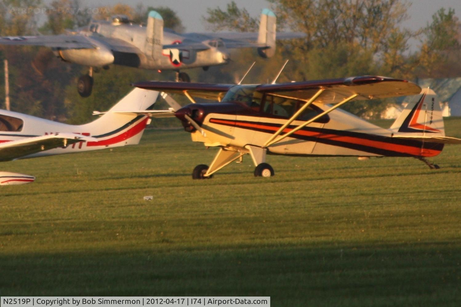 N2519P, 1955 Piper PA-22-150 C/N 22-2881, Dawn in the grass at Urbana.  B-25 N3155G departing in the background for the B-25 Gathering and Doolittle Reunion in Dayton.