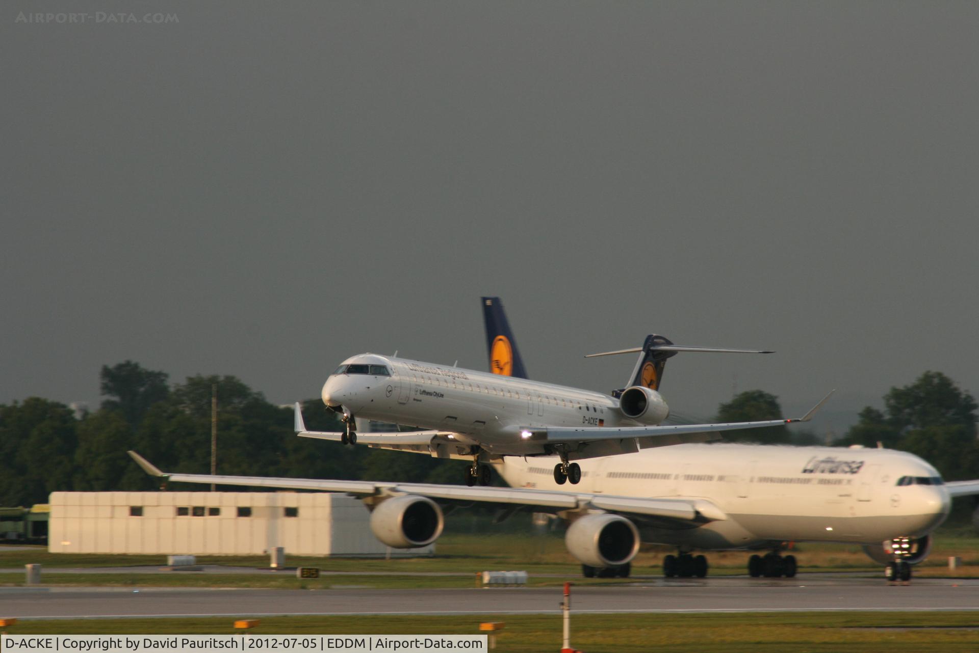 D-ACKE, 2006 Bombardier CRJ-900LR (CL-600-2D24) C/N 15081, Nice evening light in Munich. In background: Airbus A340-600 - Lufthansa