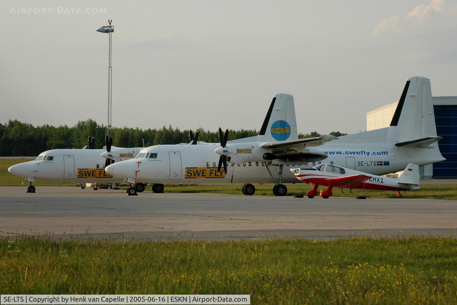 SE-LTS, 1991 Fokker 50 C/N 20230, Two Fokker 50s of SweFly, SE-LTS and SE-LTR, parked at Nyköping Skavsta airport, Sweden, together with a German Bölkow Bö-207.