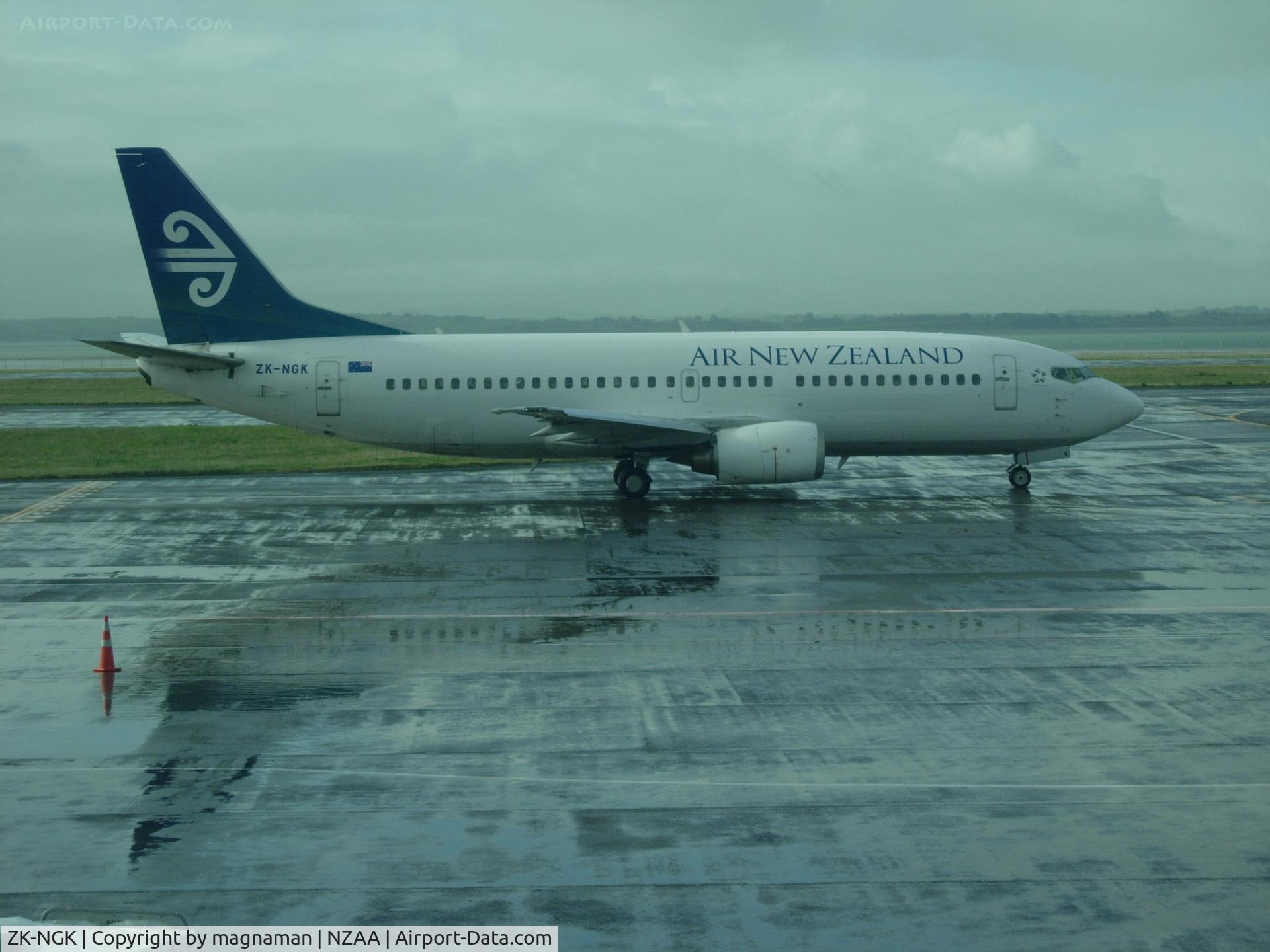 ZK-NGK, 1995 Boeing 737-3K2 C/N 26318, From a wet AKL airport - view from domestic baggage collection window.