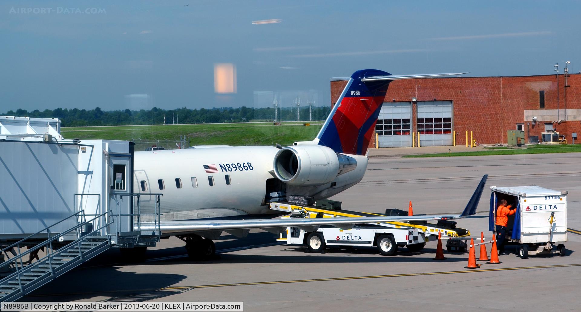 N8986B, 2004 Bombardier CRJ-200ER (CL-600-2B19) C/N 7986, Loading baggage  LEX