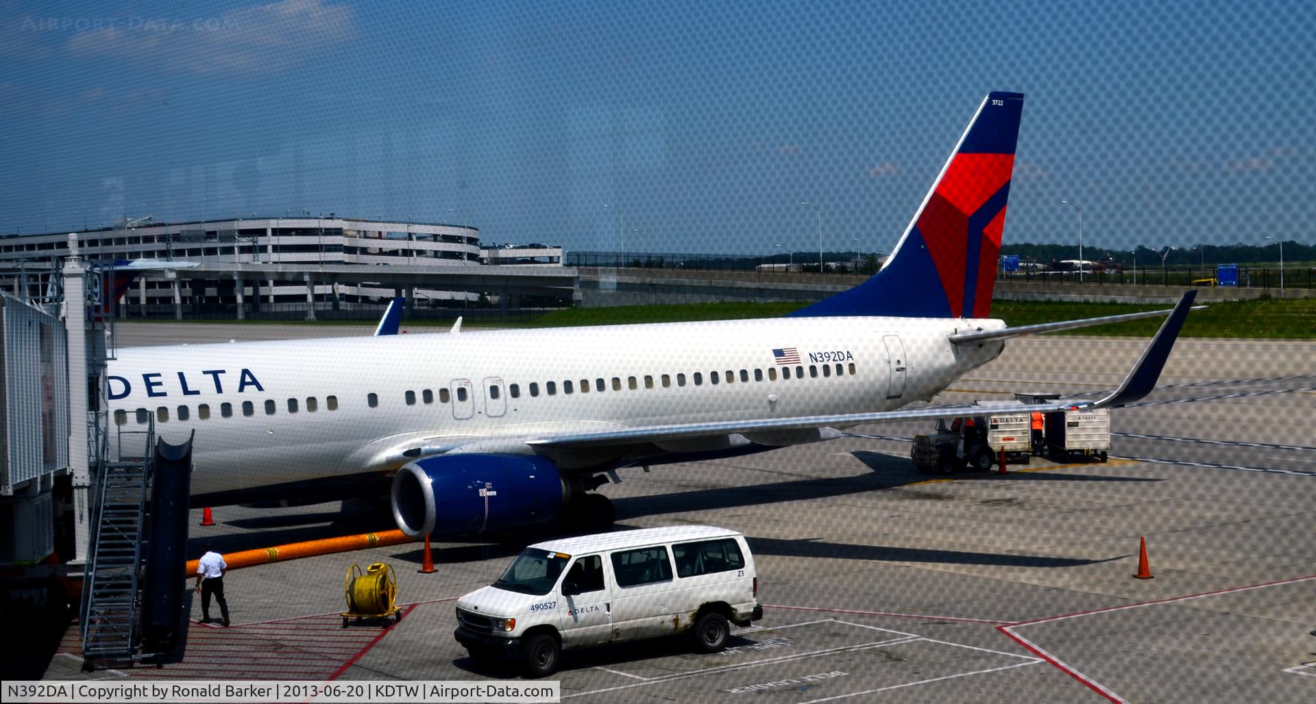 N392DA, 2000 Boeing 737-832 C/N 30561, Air hoses in place and baggage carts Gate A9 DTW