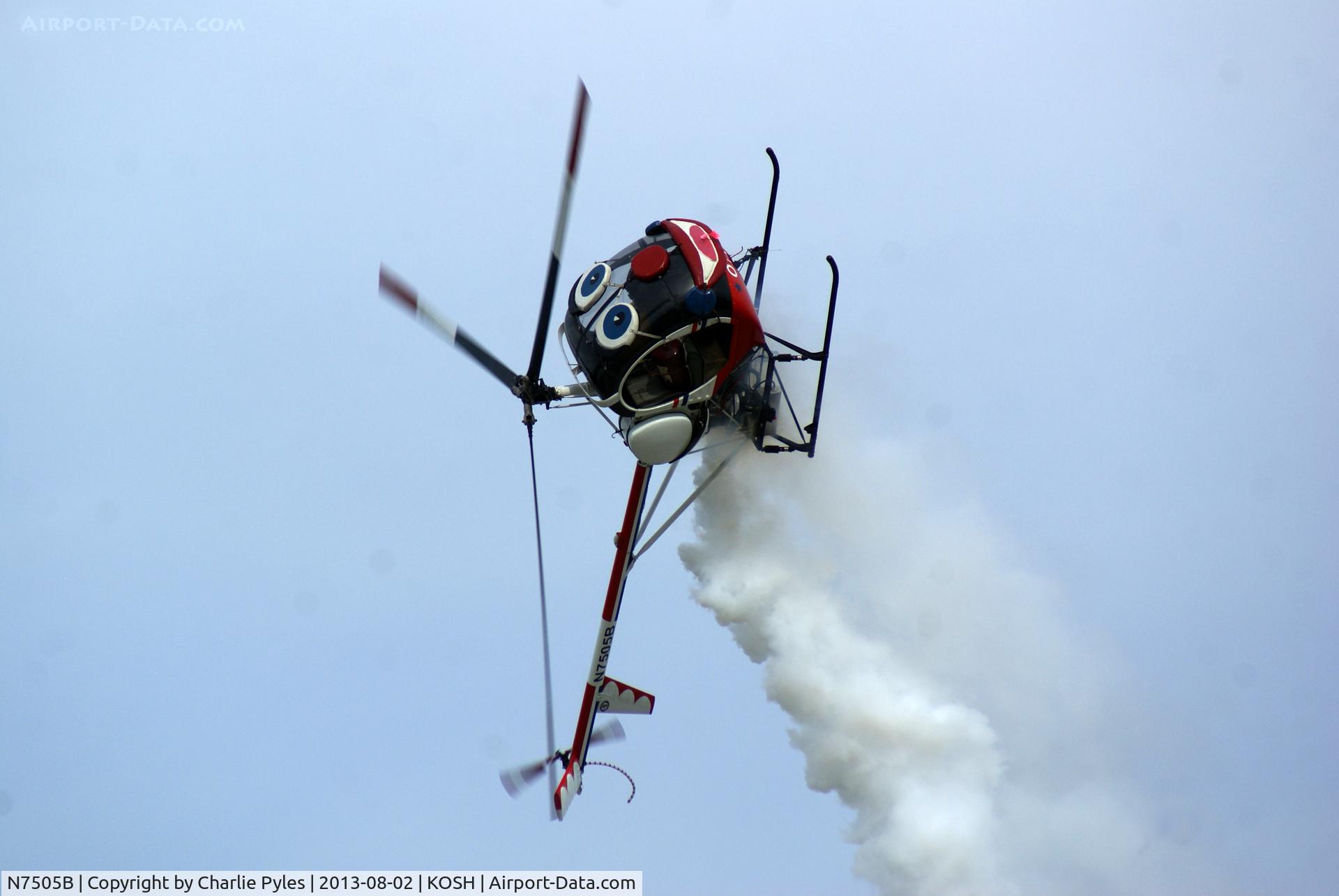 N7505B, 1985 Schweizer 300C (269C) C/N S1205, AirVenture Oshkosh 2013. 
Otto the Helicopter Clown rolls his eyes the hard way. Otto is flown by my friend Roger Buis whose lovely wife Pauline announces the act.