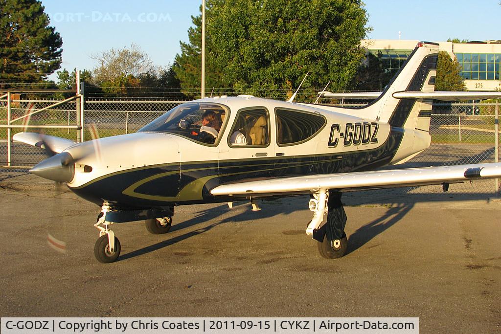 C-GODZ, 1998 Rockwell Commander 114B C/N 14659, The friendly pilot in this sharp looking Commander just started its engine beside his hangar. It would soon be flying away through some choppy wind.