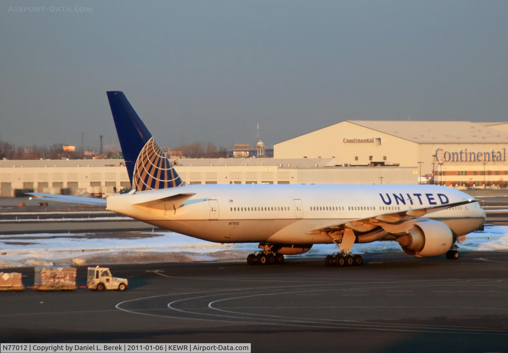 N77012, 1999 Boeing 777-224 C/N 29860, A newly painted ex-CO Boeing 777 makes her way to the taxiway on a cold January evening at Newark.