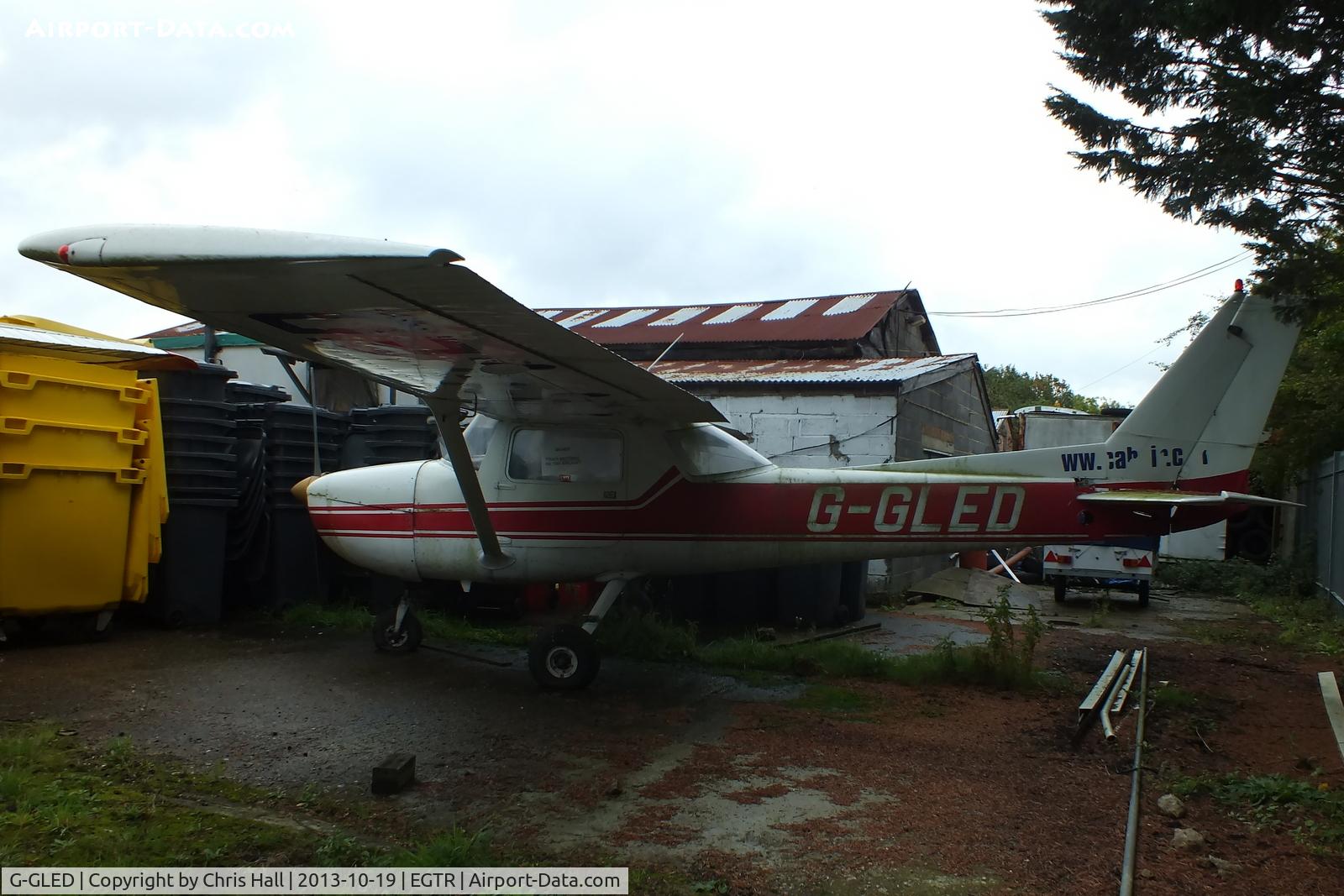 G-GLED, 1975 Cessna 150M C/N 150-76673, parked in the gap between two hangars