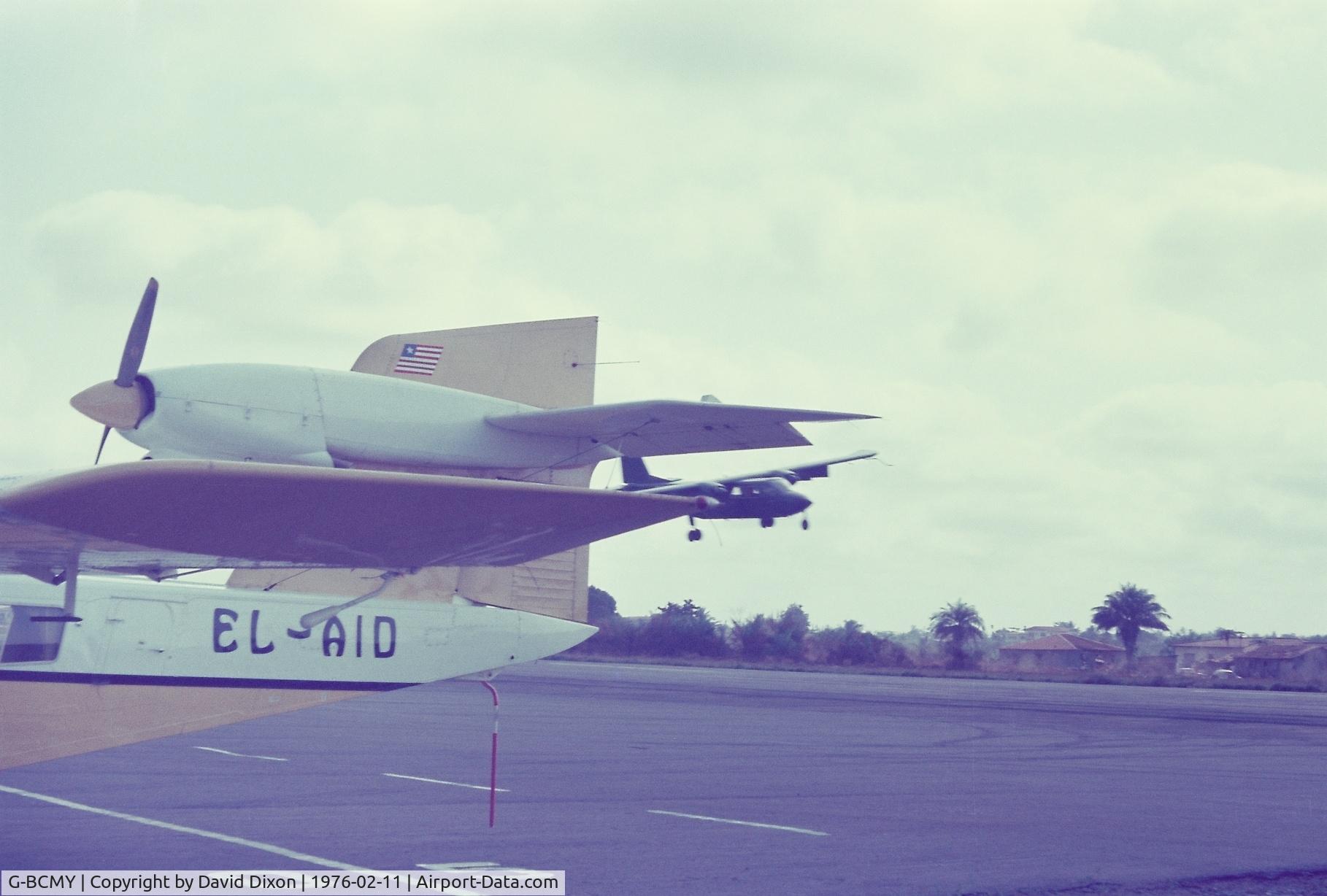 G-BCMY, 1974 Britten-Norman BN-2T Islander C/N 419, Defender demonstrator aircraft on tour in West Africa. Flown by Peter Phillips in one of his trade mark routines over Spriggs Payne Airport emerging from behind a Trislander of Air Liberia.