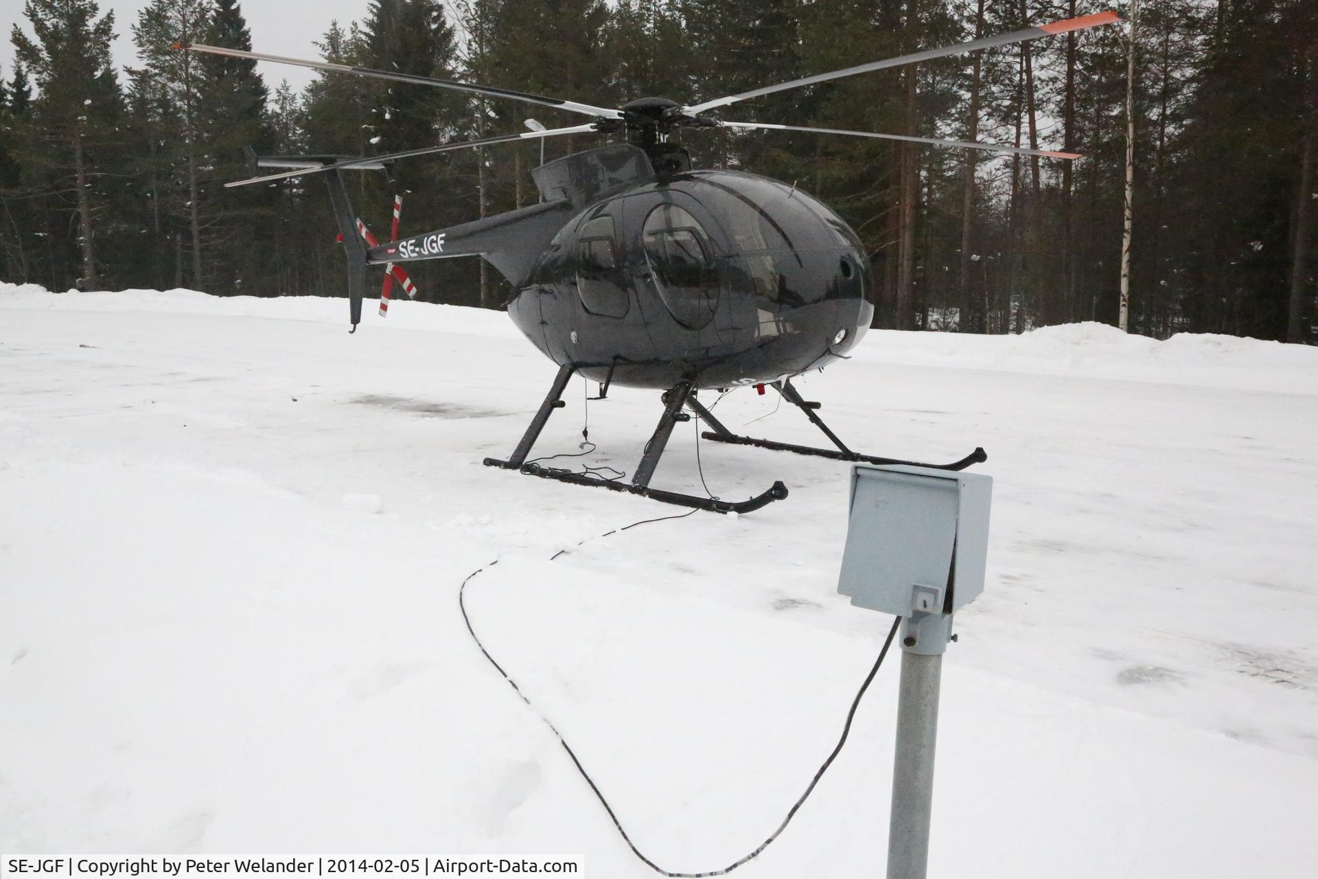 SE-JGF, 1976 Hughes 369D C/N 1160037D, Parked in the carpark outside Hotel Södra Berget in Sundsvall on Feb 5, 2014. Apparently, the pilot had landed for a night at the hotel and maybe have some grilled reindeer in the restaurant. A fan heater was plugged into the power outlet for cars.