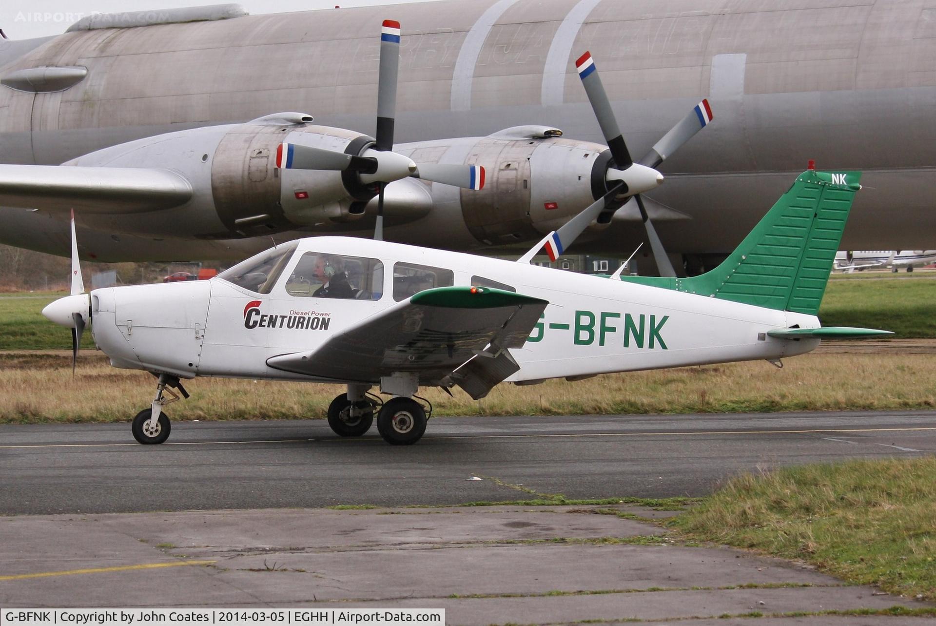 G-BFNK, 1977 Piper PA-28-161 Cherokee Warrior II C/N 28-7816282, Taxies past the CL44