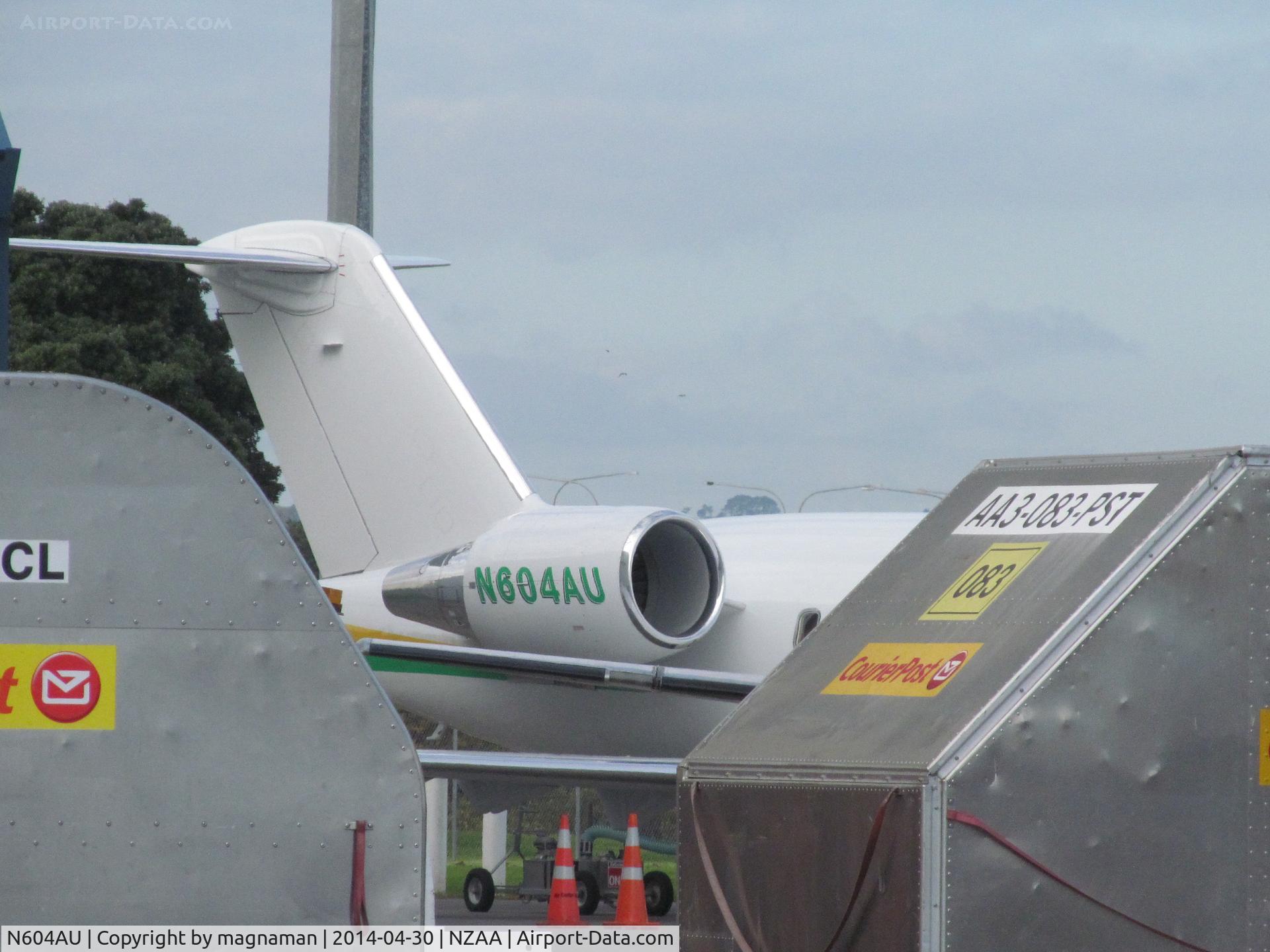 N604AU, 1999 Bombardier Challenger 604 (CL-600-2B16) C/N 5434, I'm hiding behind the cargo trailers trying not to be seen. Shame the angles were all wrong on this nice green and yellow jet.