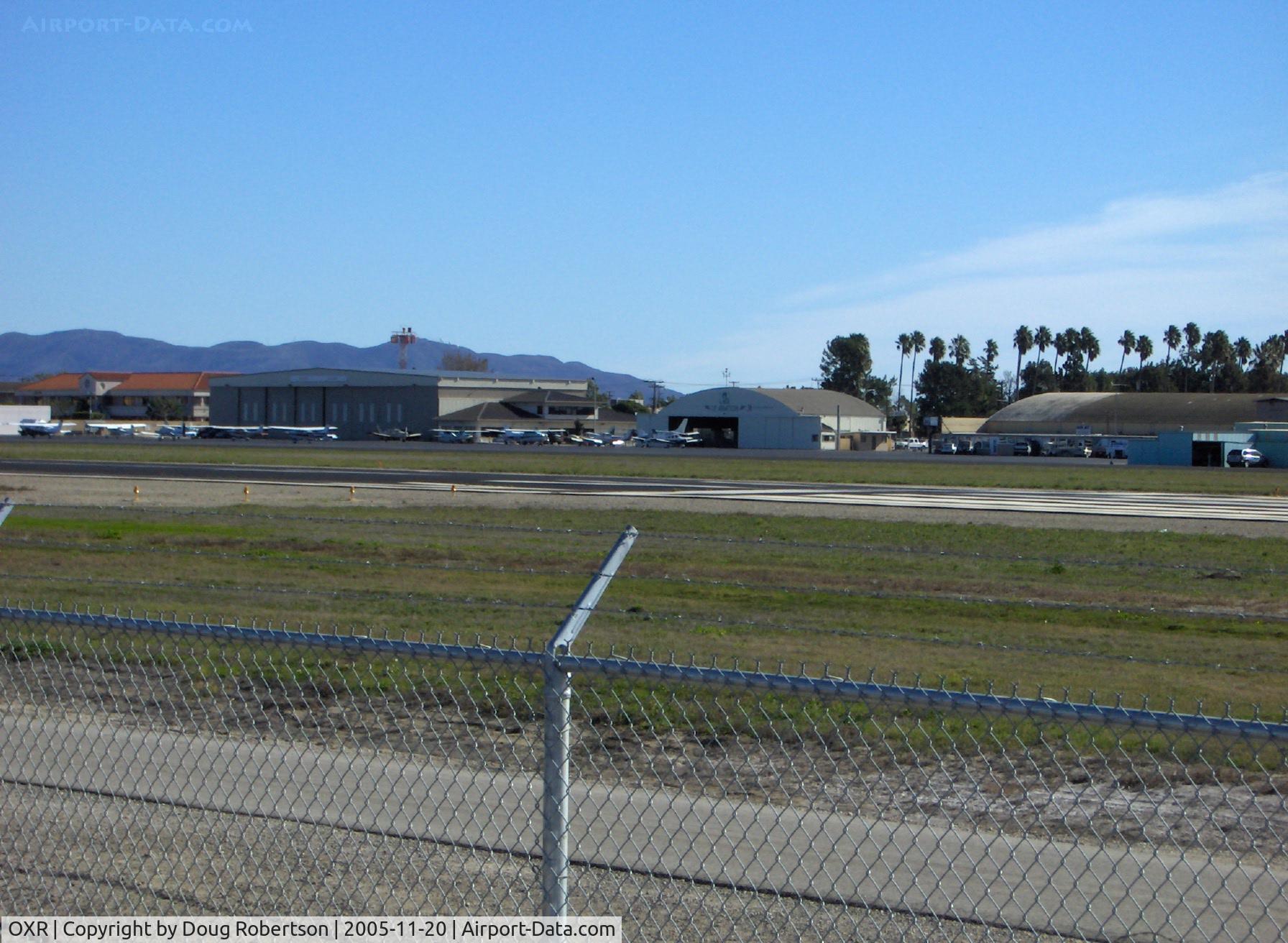 Oxnard Airport (OXR) - OXR Runway 07-25, 5,953' X 100' asphalt, Million Air Hangar Southeast end. OXR was a Civilian Pilot Training Program field from 1939 onward thru World War II. Mira Loma Academy pilot housing across Fifth Street south of field now low-cost rental housing.