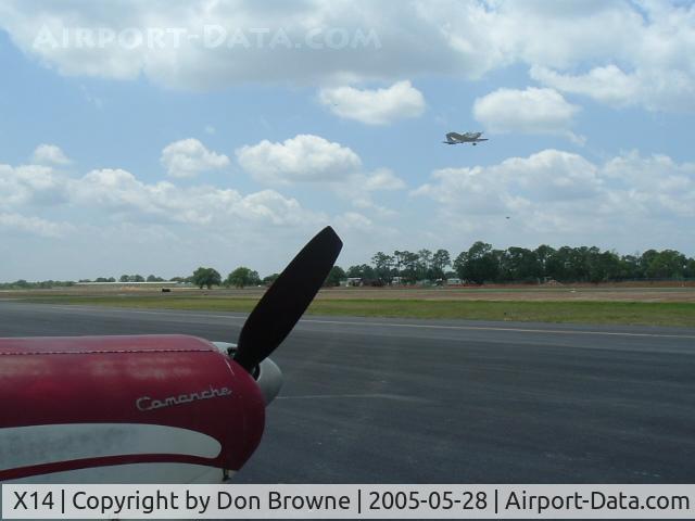 La Belle Municipal Airport (X14) - PA-24 180 Piper Comanche (N7569P) in foreground as unknown aircraft takes off on new runway at LaBelle, Fl.