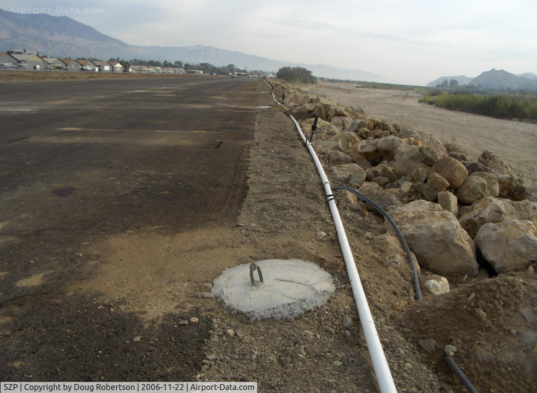 Santa Paula Airport (SZP) - New aircraft tiedown pads set in concrete-tail tiedown pads-Santa Clara River bank right adjacent-Note really muddy fast & high waters!