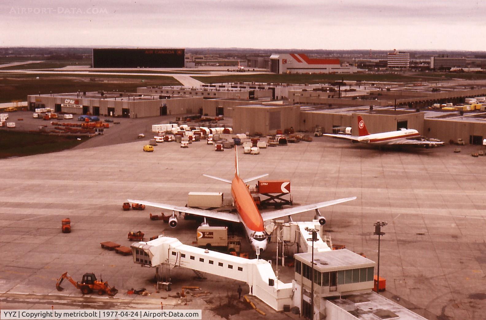 Toronto Pearson International Airport (Toronto/Lester B. Pearson International Airport, Pearson Airport), Toronto, Ontario Canada (YYZ) - YYZ in 1977.Taken from the old terminal 1 carpark.CP Air DC-8-63,with Air Canada DC-8 at the AC Cargo terminal.Background CP Air hangar with CP B747