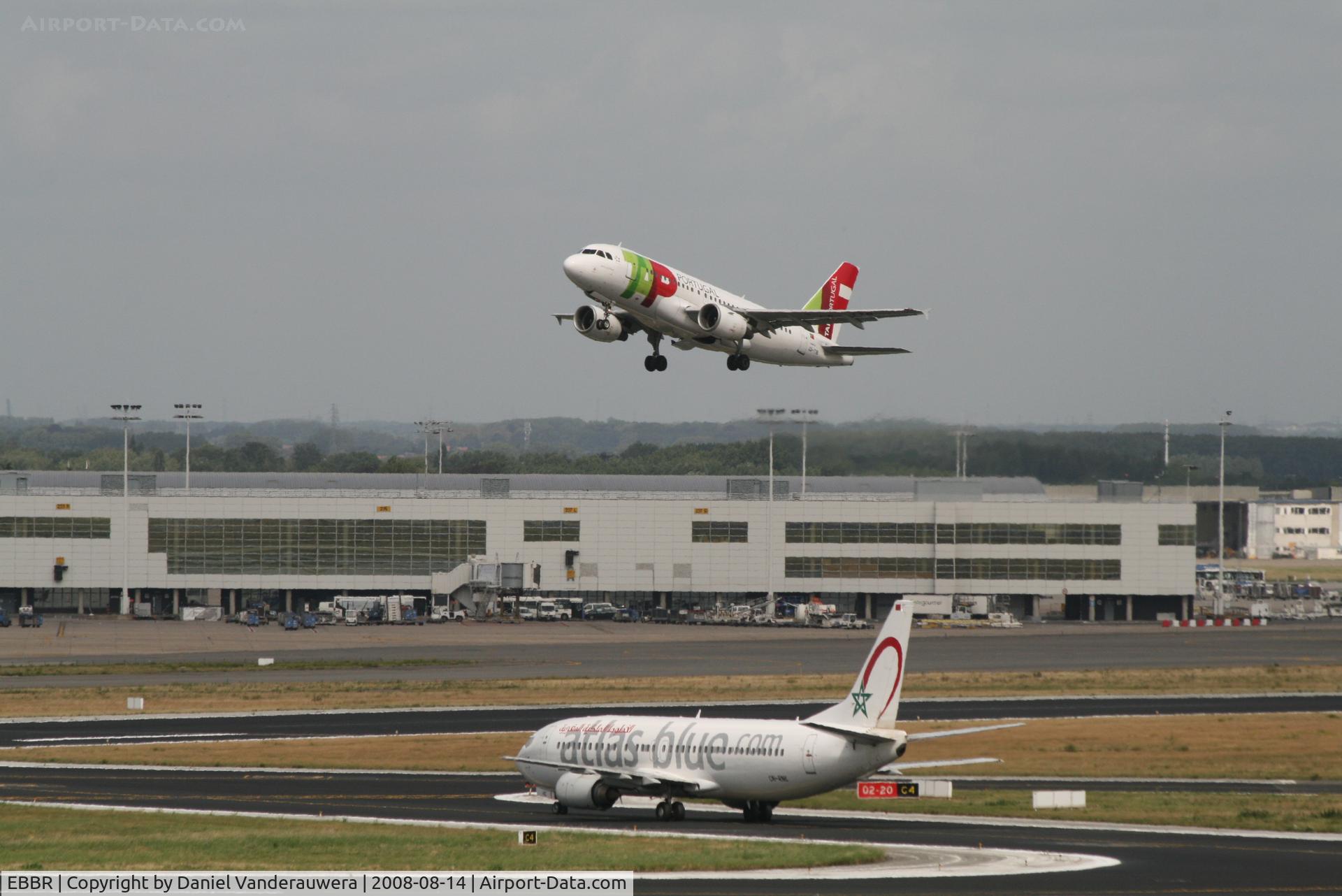 Brussels Airport, Brussels / Zaventem   Belgium (EBBR) - flight TP605 (A319-111 - CS-TTB) is taking off from rwy 20.  In background is Pier B - 