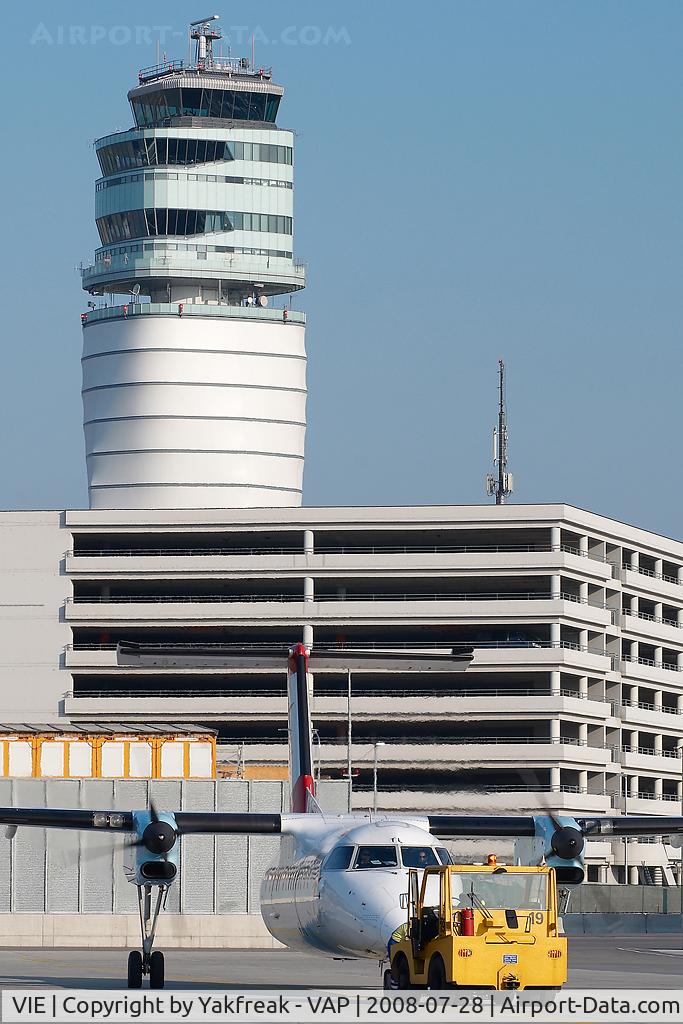 Vienna International Airport, Vienna Austria (VIE) - Dash 8 pushing back in front of ATC tower