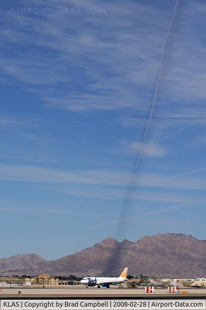 Mc Carran International Airport (LAS) - I found this very bizarre: the sun was in the right position to cast a shadow of overhead contrails on the mountain in the background.  Ted Airlines N470UA awaiting take-off