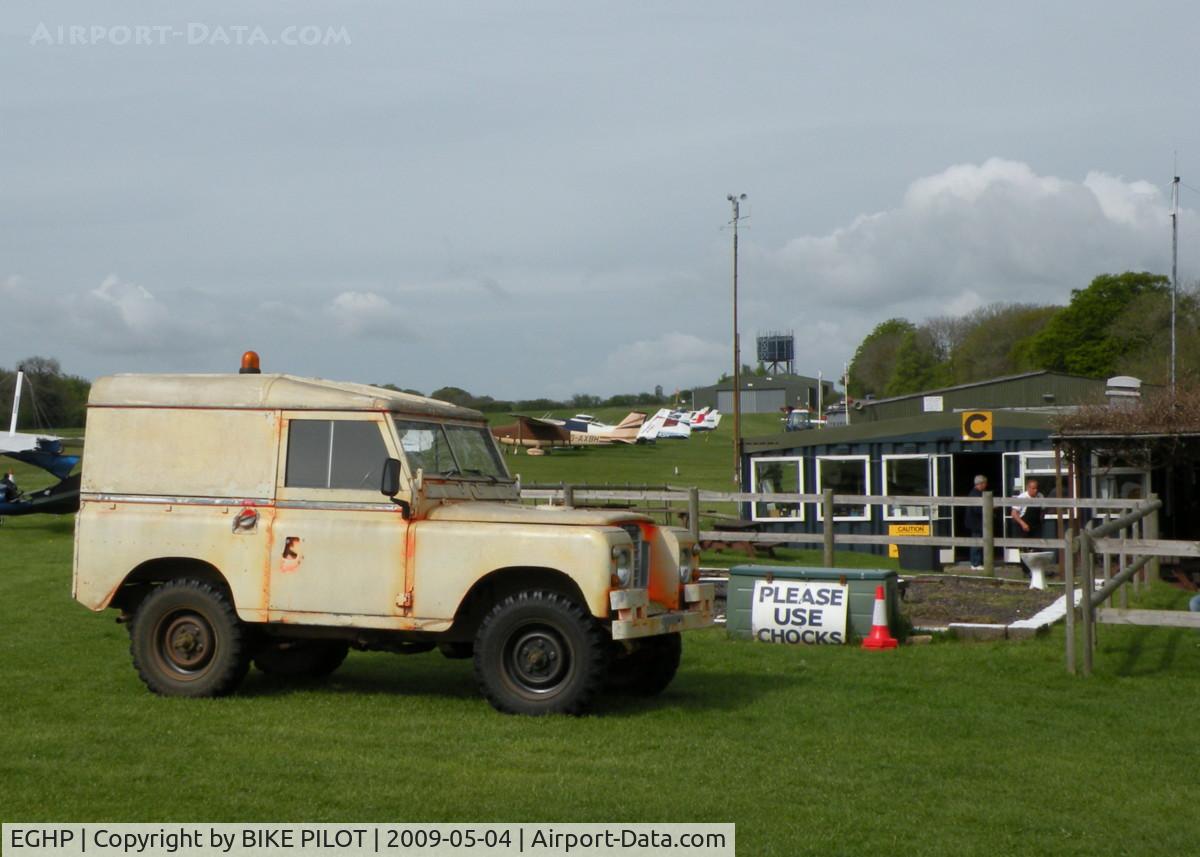 Popham Airfield Airport, Popham, England United Kingdom (EGHP) - AIRFIELD LAND ROVER IN FRONT OF THE CLUB HOUSE, I THINK THE ORANGE DAY-GLO'S FADED A TAD !