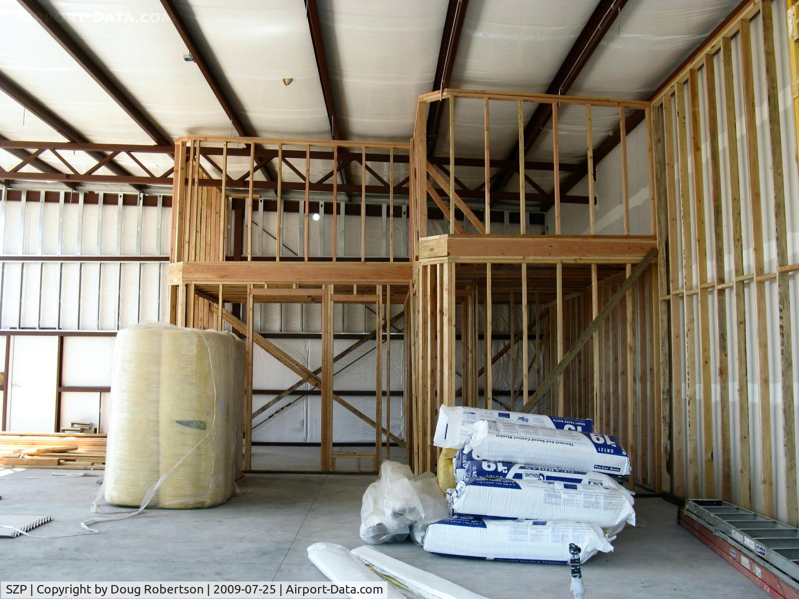 Santa Paula Airport (SZP) - New hangar under construction. Insulated, internal wall studs, framing for two-story rooms in corner. Photo taKen through picture window opening which overlooks runway.