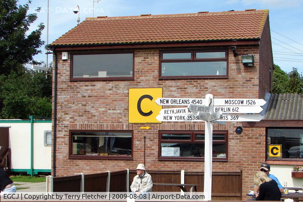Sherburn-in-Elmet Airfield Airport, Sherburn-in-Elmet, England United Kingdom (EGCJ) - Signpost outside the Control Tower at Sherburn - although I don't think these exotic destinations will be reached direct from this GA field !!!!
