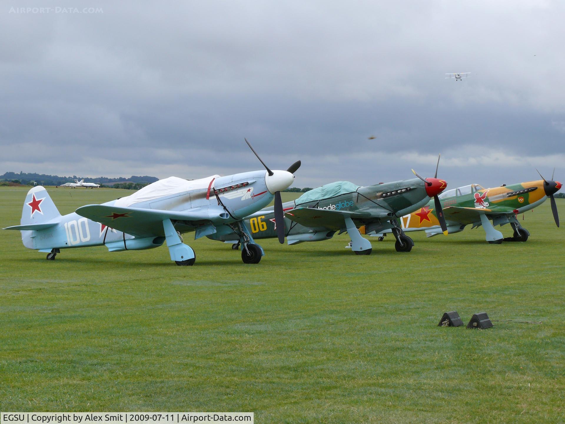 Duxford Airport, Cambridge, England United Kingdom (EGSU) - Beautiful line of Yak-fighters waiting for the action at the Legends 2009