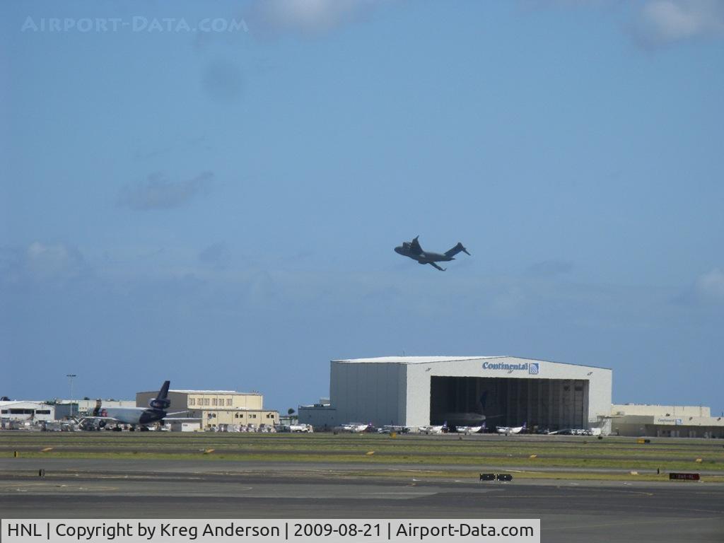 Honolulu International Airport (HNL) - A view of the cargo ramp and CO hangar, complete with a C-5 taking off beyond it.