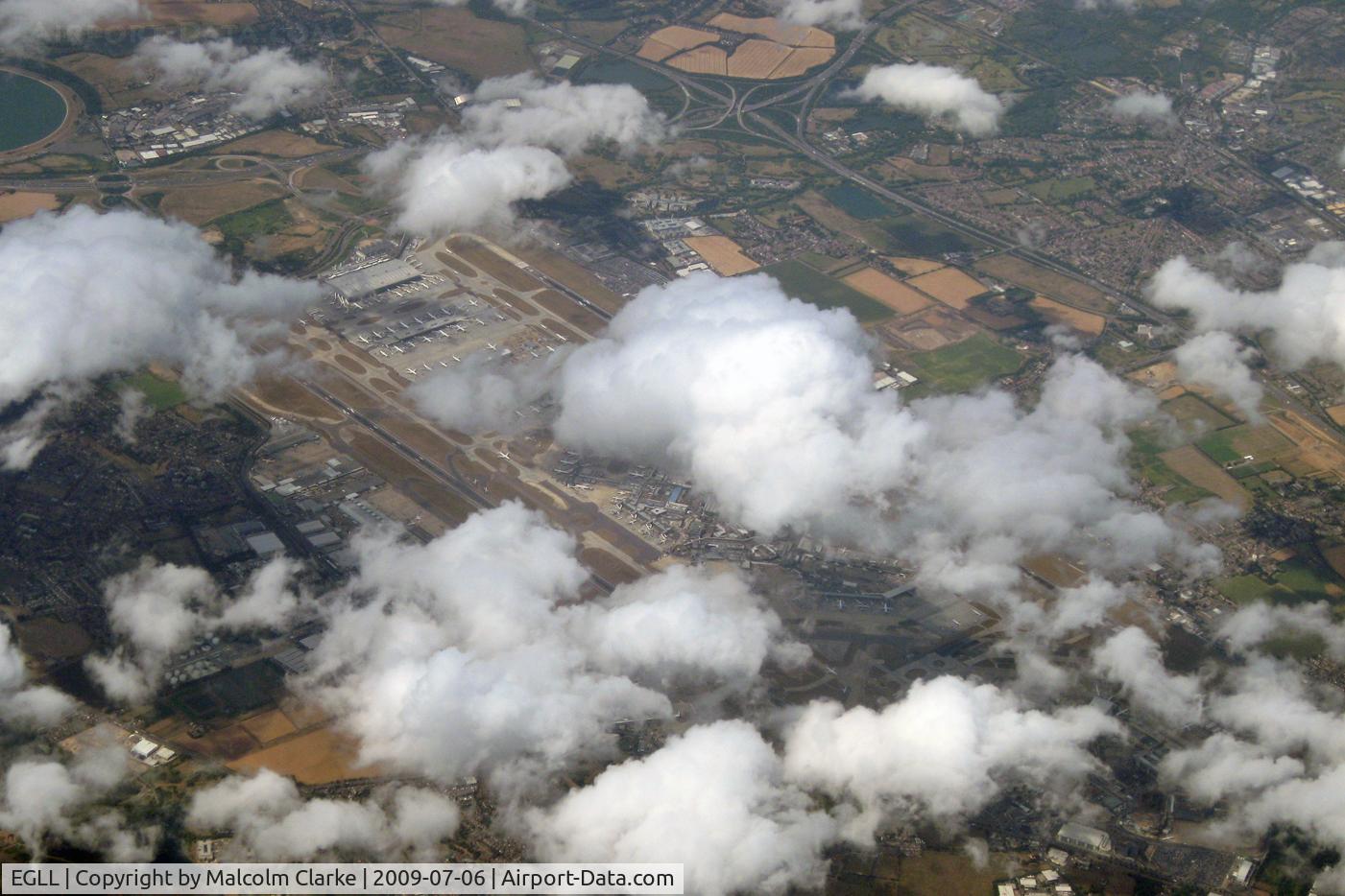 London Heathrow Airport, London, England United Kingdom (EGLL) - Just a glimpse of London Heathrow through the clouds, on a return flight to Newcastle from Jersey in 2009..