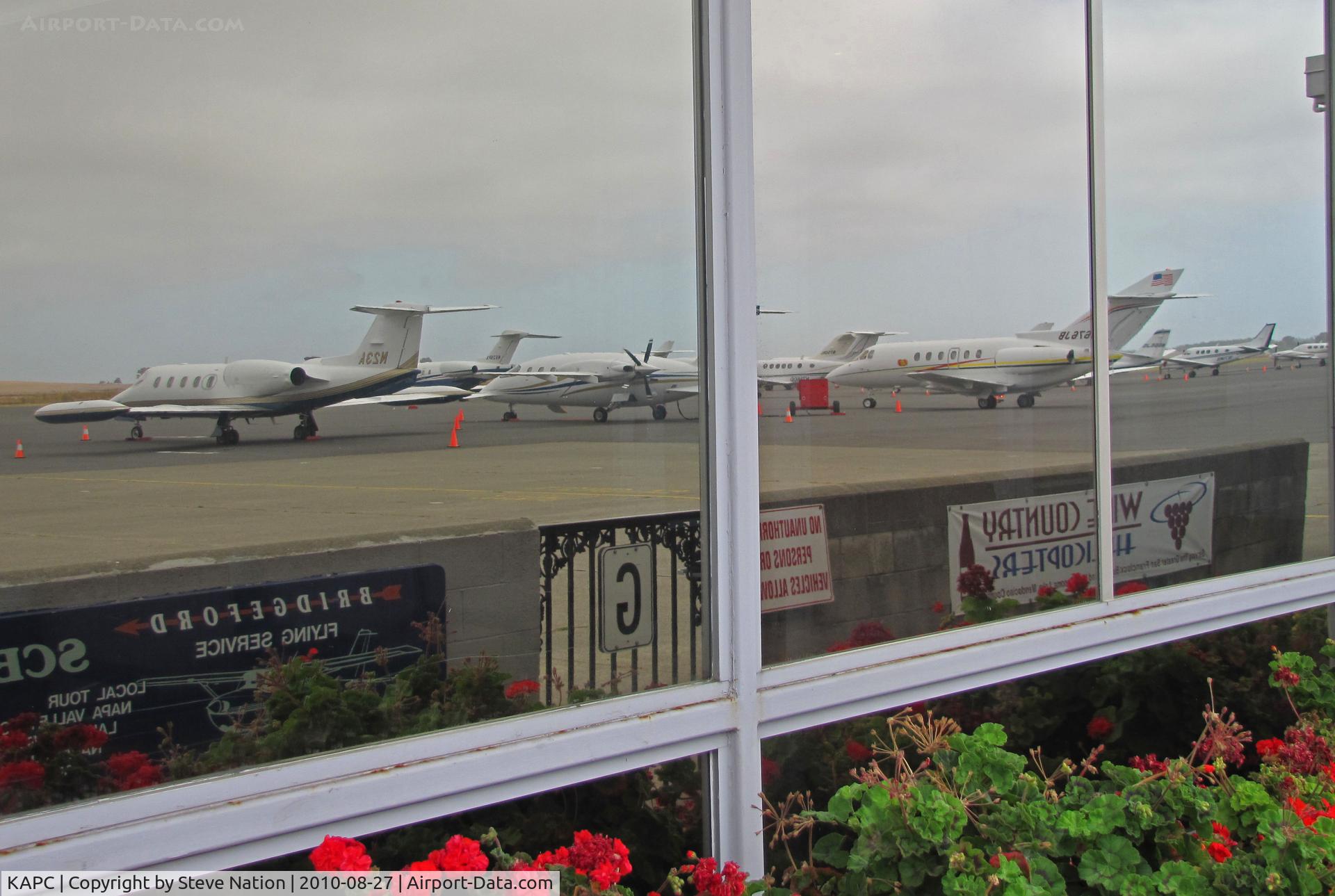 Napa County Airport (APC) - Full bizjet ramp reflected in terminal window